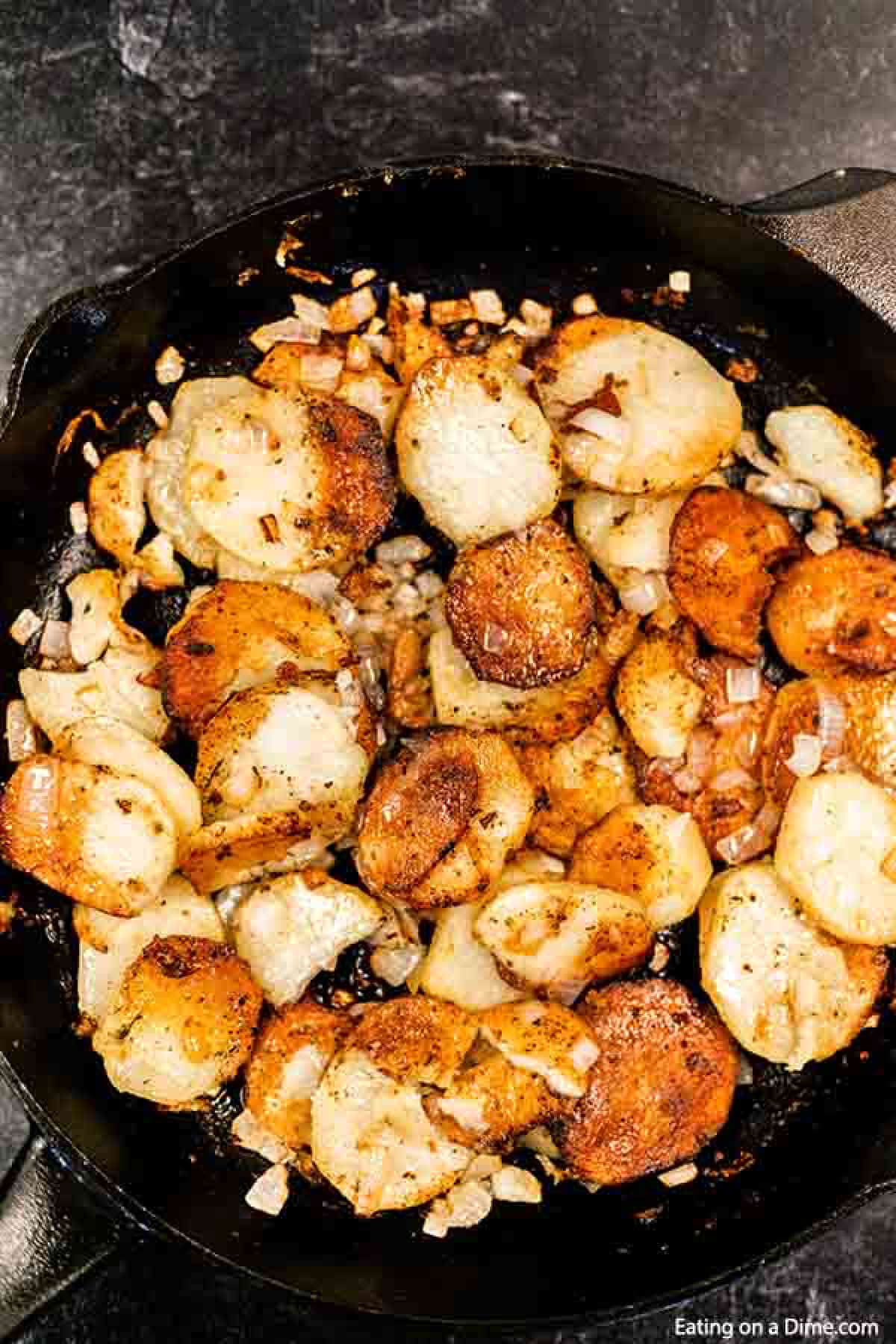 Pan fried potatoes with chopped onions in a cast iron skillet