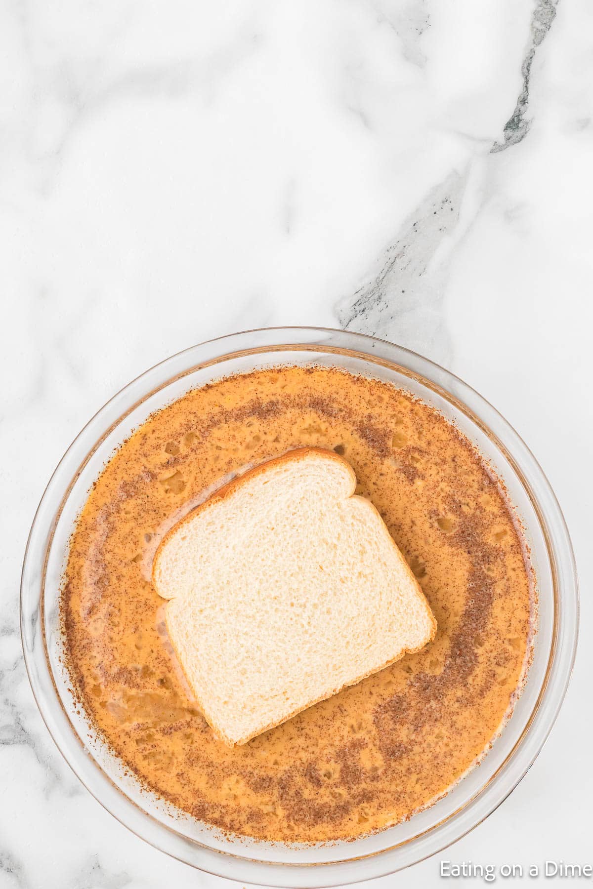 White bread dipped into the egg mixture in a shallow dish