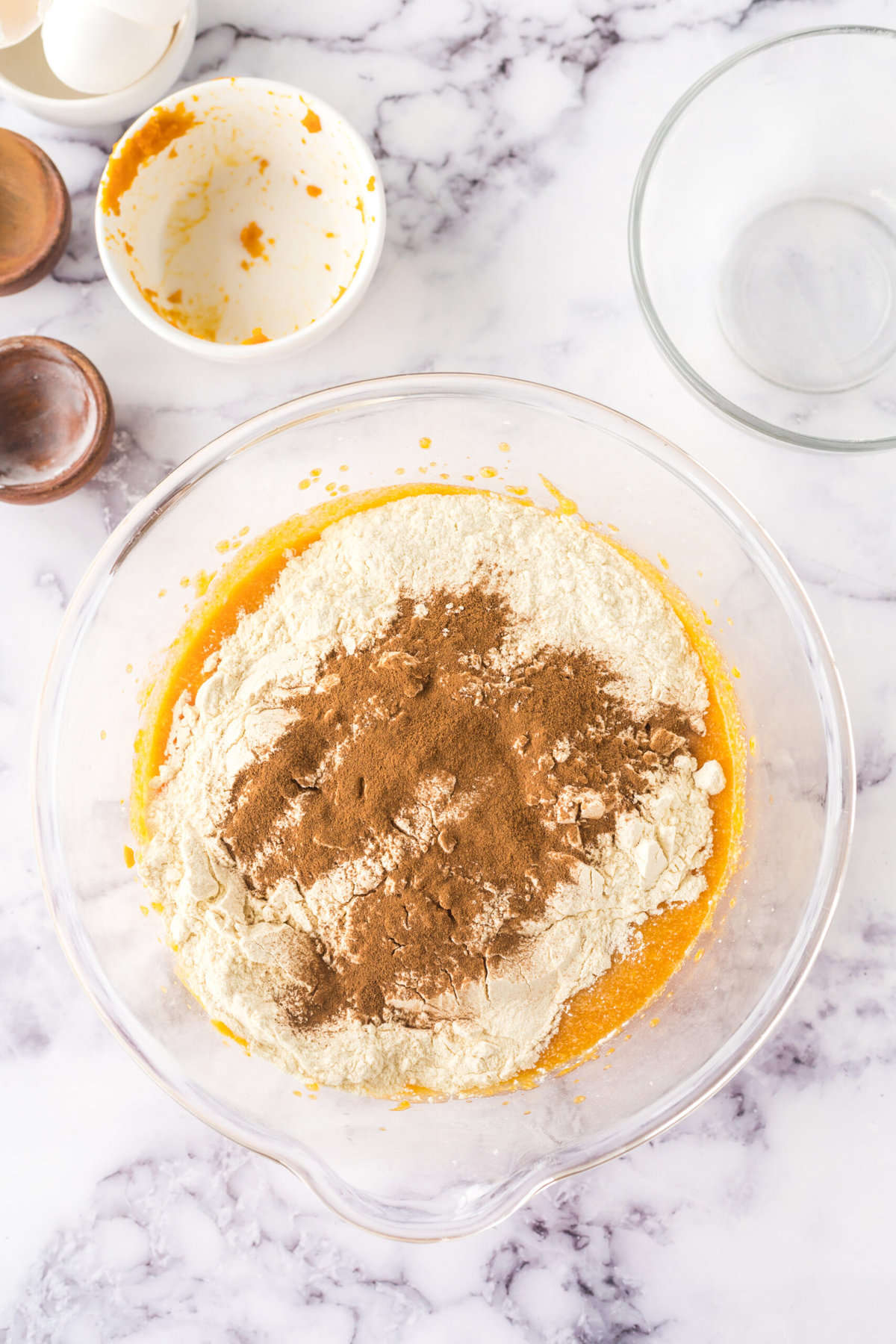 Topping the pumpkin mixture with flour and cinnamon in a bowl
