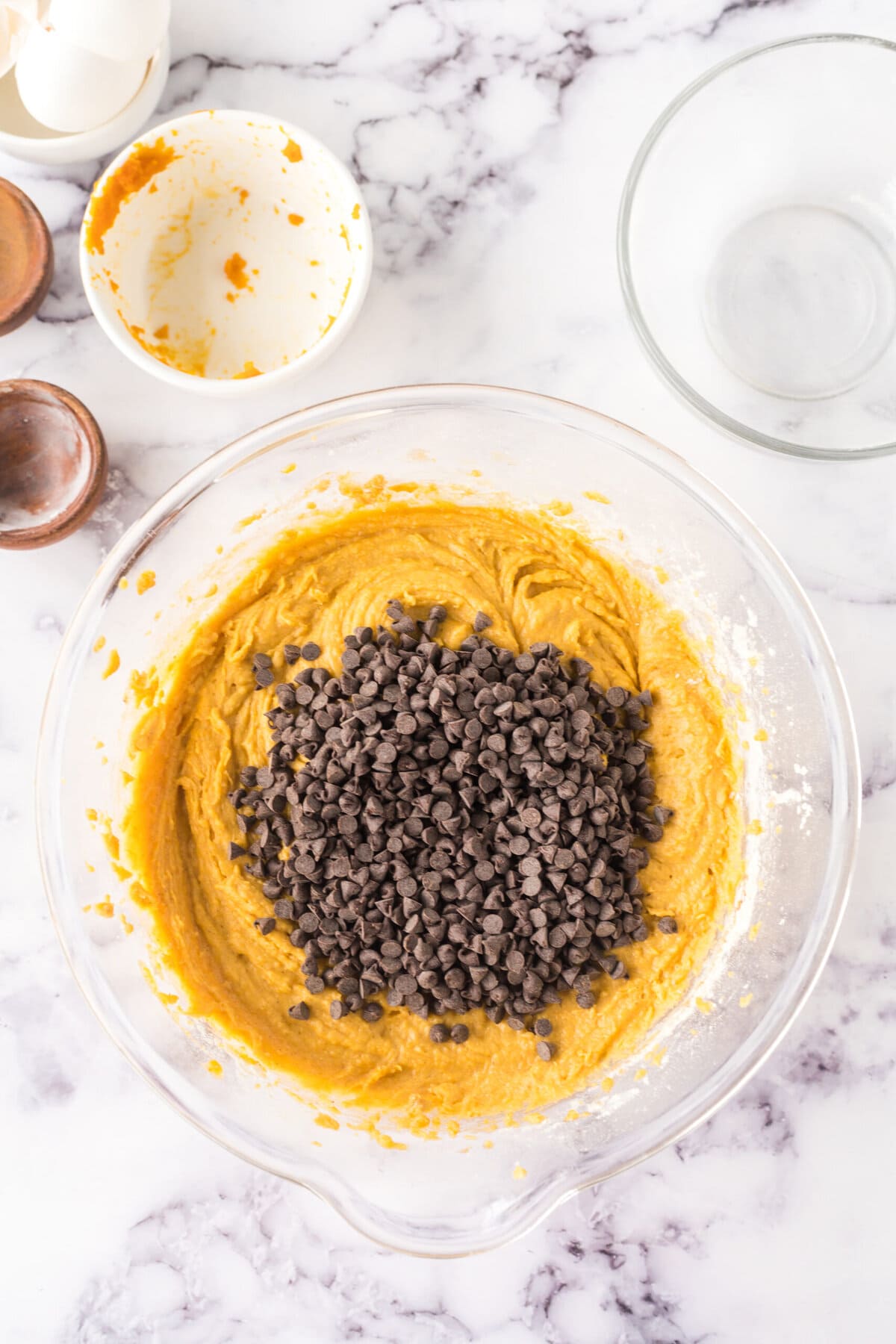 Topping the pumpkin bread batter with chocolate chips in a bowl