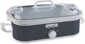 A black and white Crock-Pot slow cooker with a transparent lid and white handles. The front panel boasts a single dial with three settings: Low, High, and Warm. The brand name "Crock-Pot" is displayed above the dial, making it one of the best crock pots available.