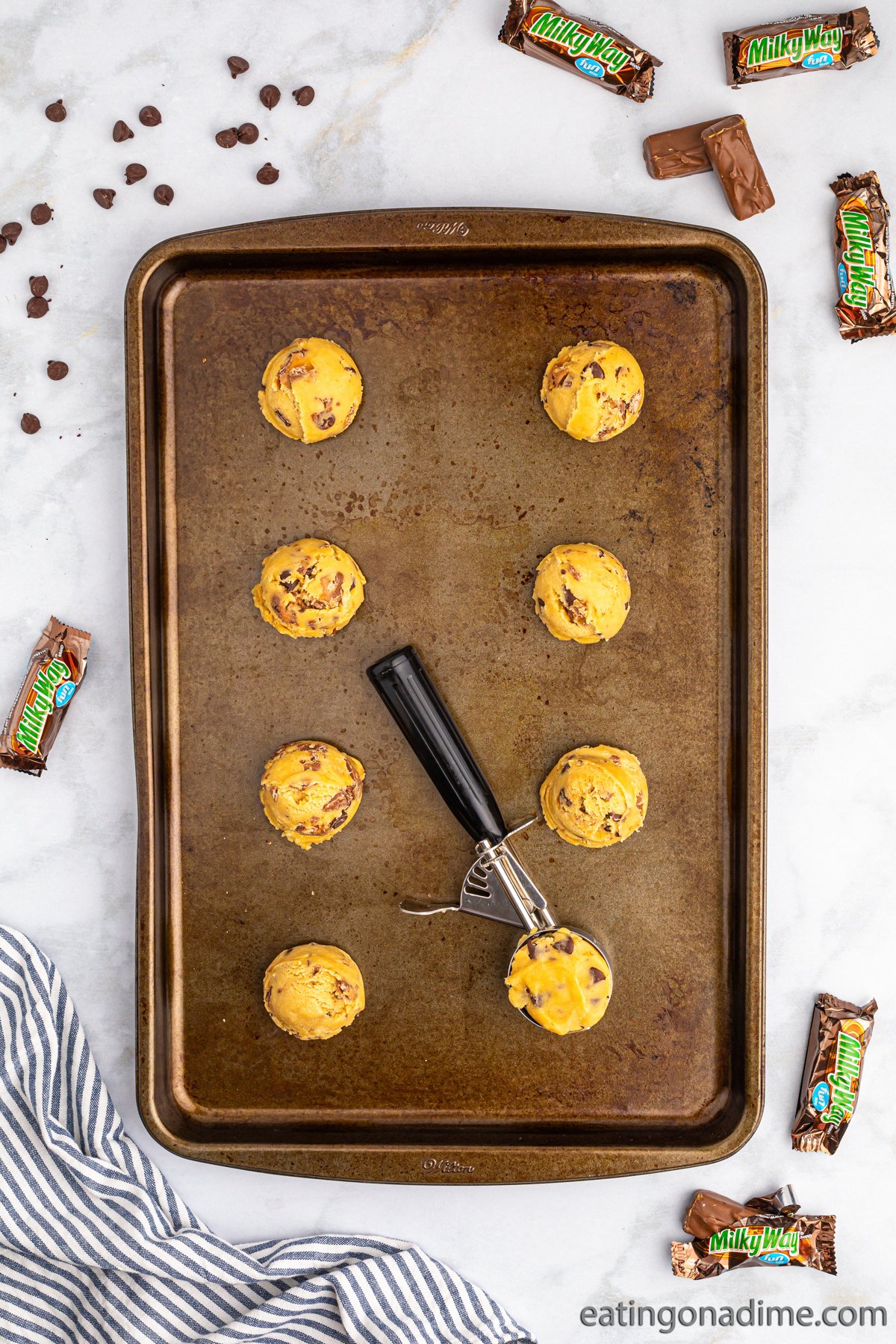 Scooping the dough with a ice cream scoop and placing on a baking sheet