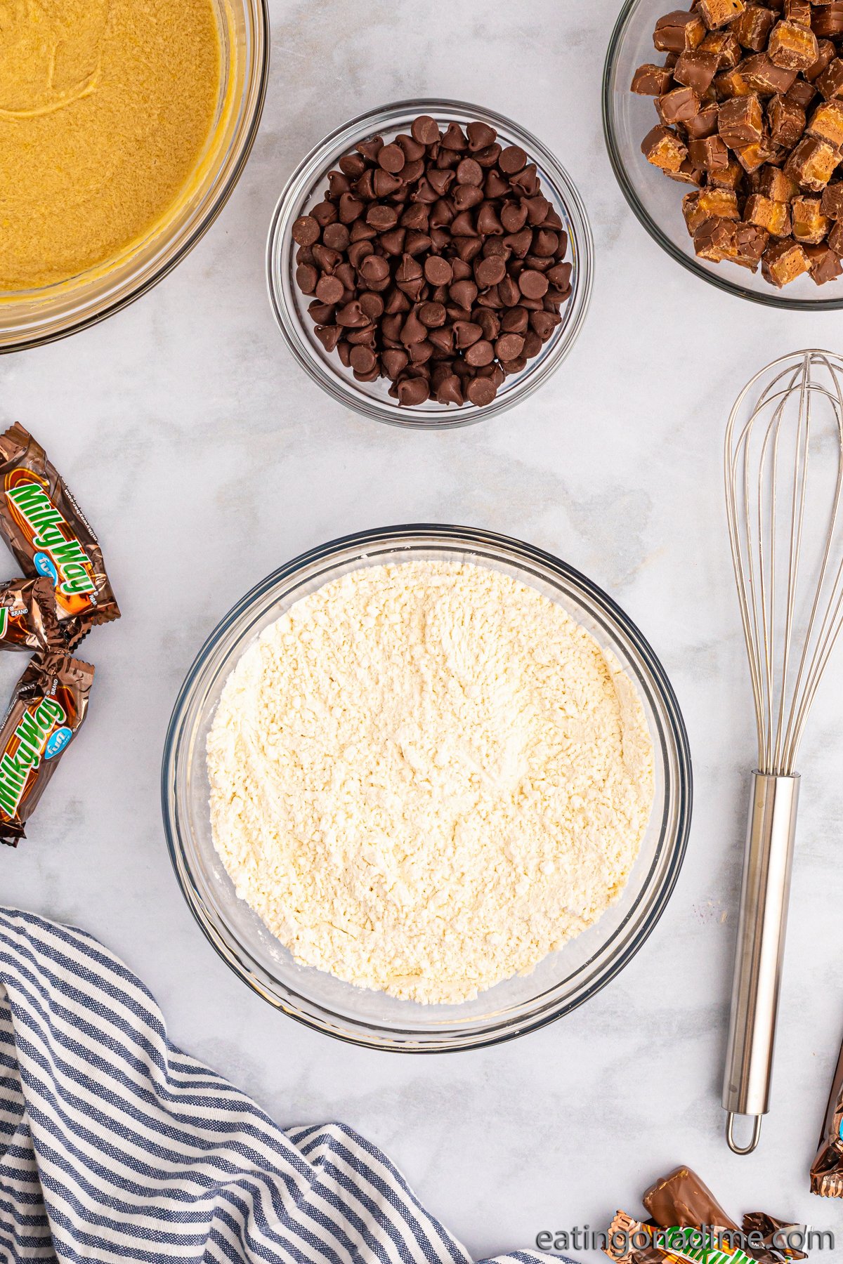 Mix dry ingredients in a bowl with a bowl of chocolate chips, chopped candy bars and brown sugar mixture in a bowl