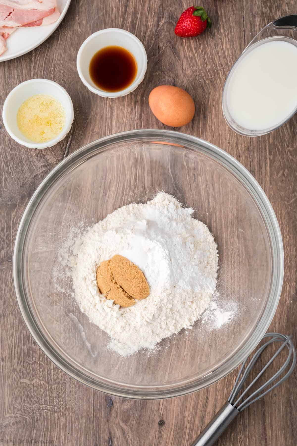 Flour, brown sugar, baking powder and salt in a bowl with small bowls with melted butter and vanilla