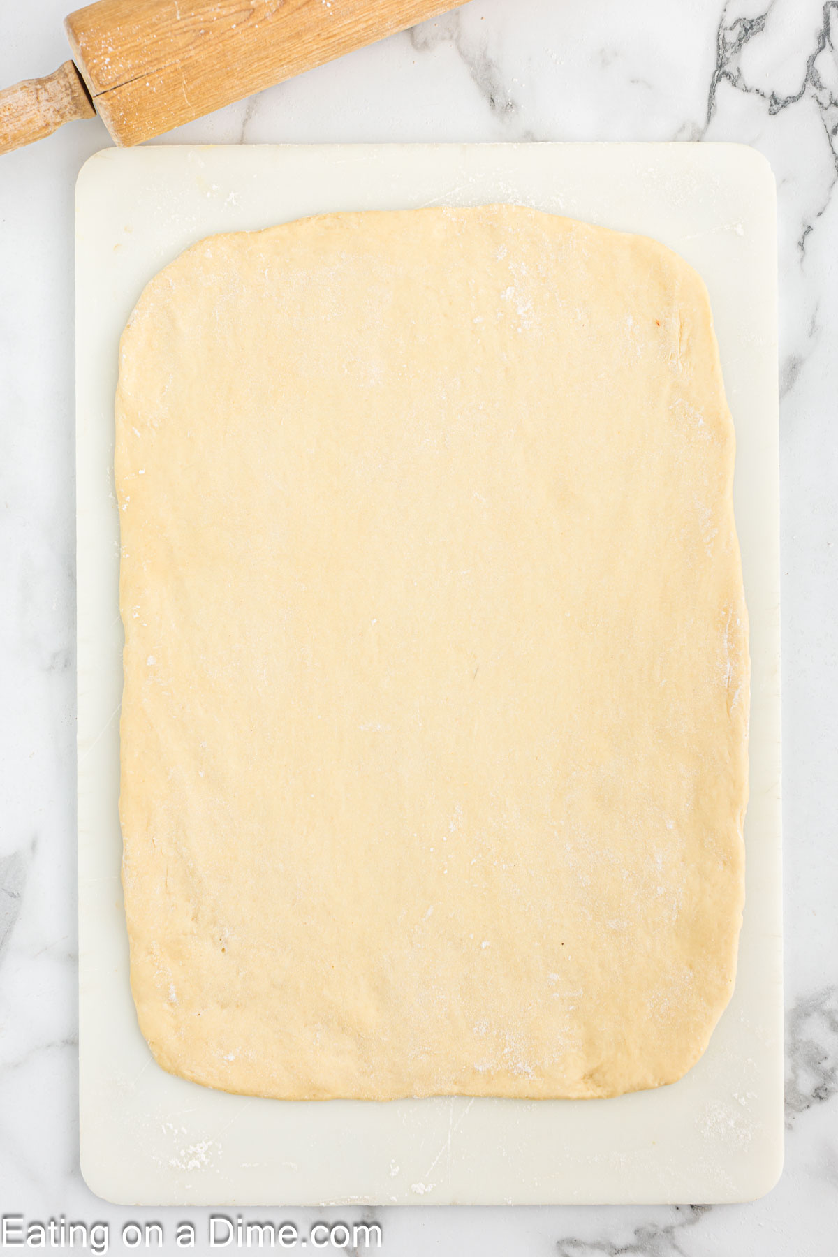 Dough spread into a rectangle shake on a cutting board