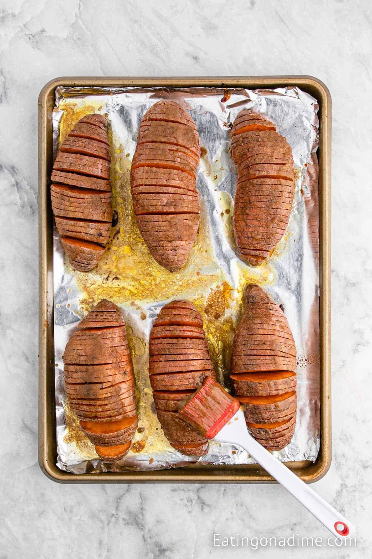 Sliced sweet potatoes on a foil lined baking sheet 