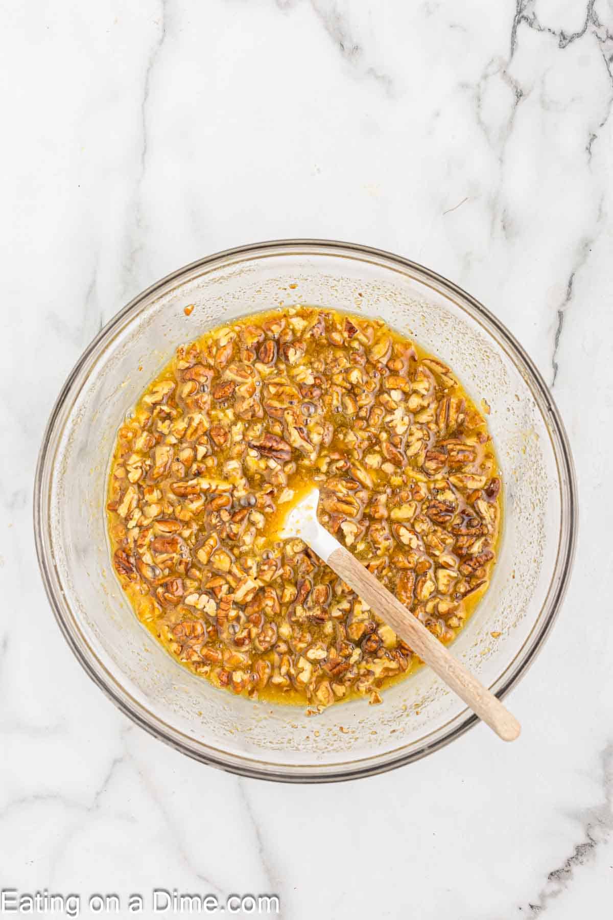 Pecan pie filling in a bowl with chopped pecans in a bowl