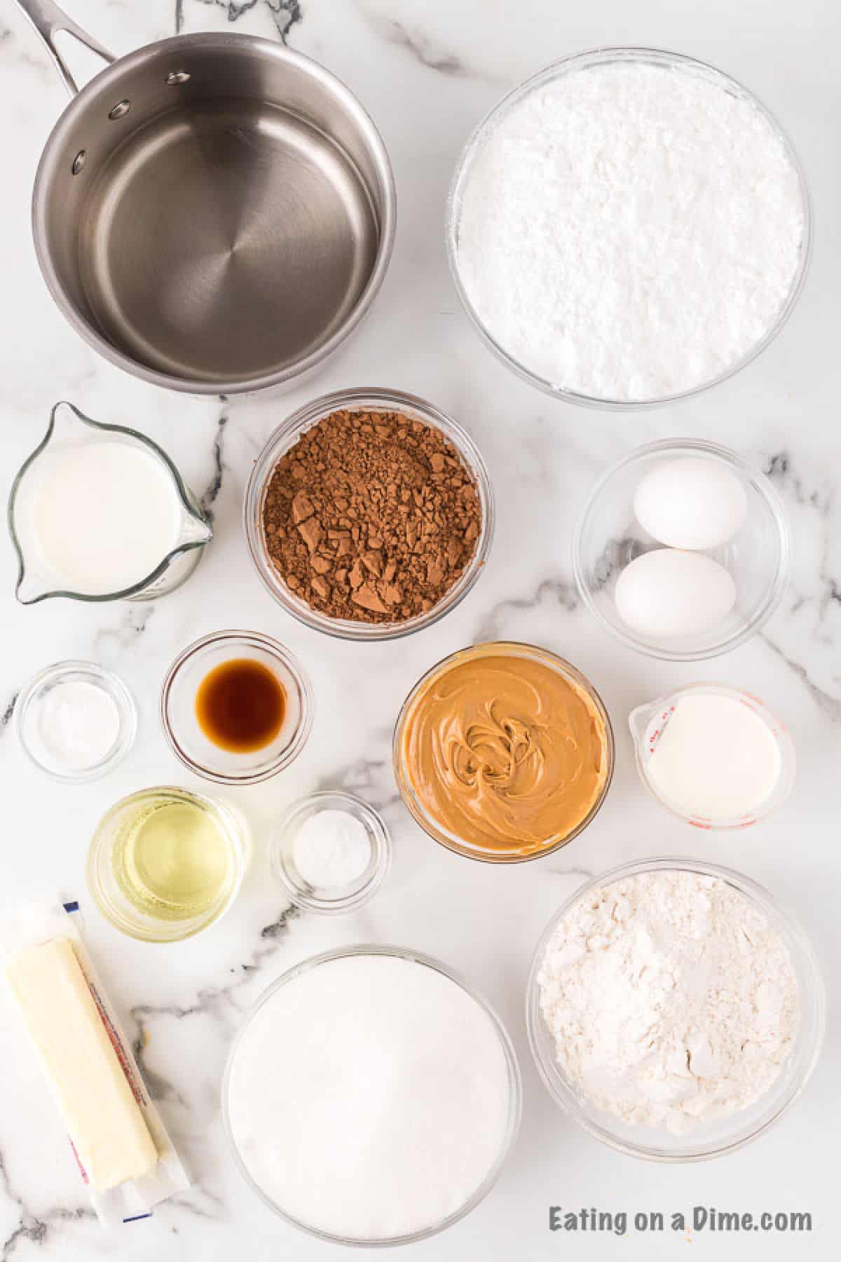 Image of the ingredients to make the chocolate peanut butter cupcakes - flour, sugar, cocoa powder, baking soda, baking powder, salt, eggs, milk, oil, vanilla extract, boiling water, butter, peanut butter, heavy whipped cream, powdered sugar