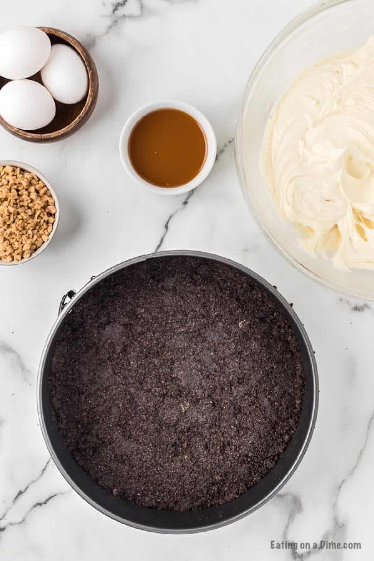 Pressing the crushed Oreo mixture into the pan