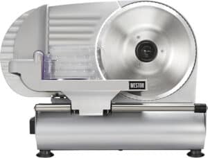 A silver meat slicer, touted among the best meat slicers, features a round blade on the right and a food carriage with guide on the left. The brand "Weston" is prominently displayed, enhancing its sleek and industrial design.