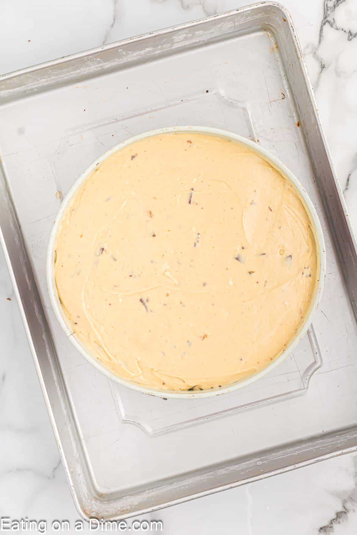 Reese's Cheesecake batter poured into springform pan placed in a roasting pan