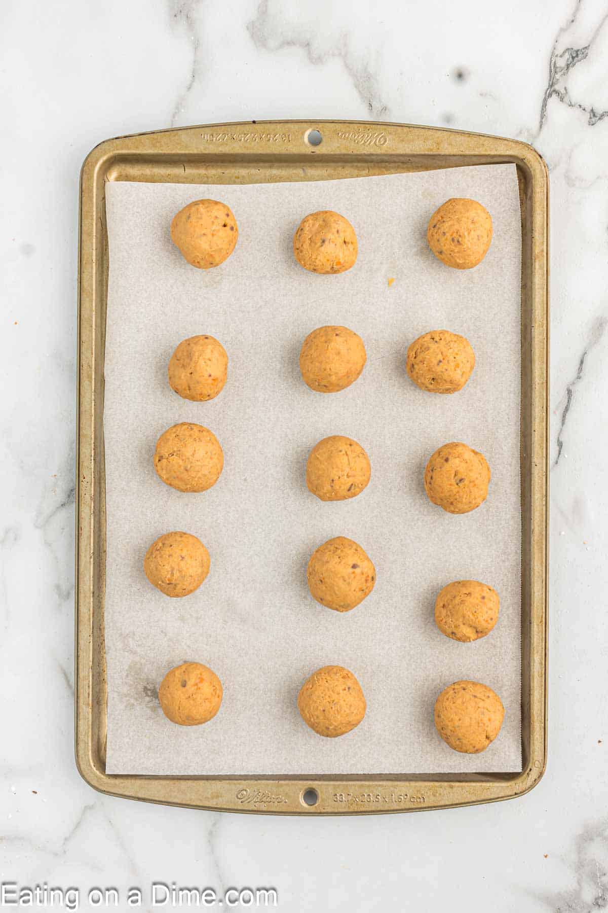 Butterfinger mixture rolled into balls on a baking sheet lined with parchment paper