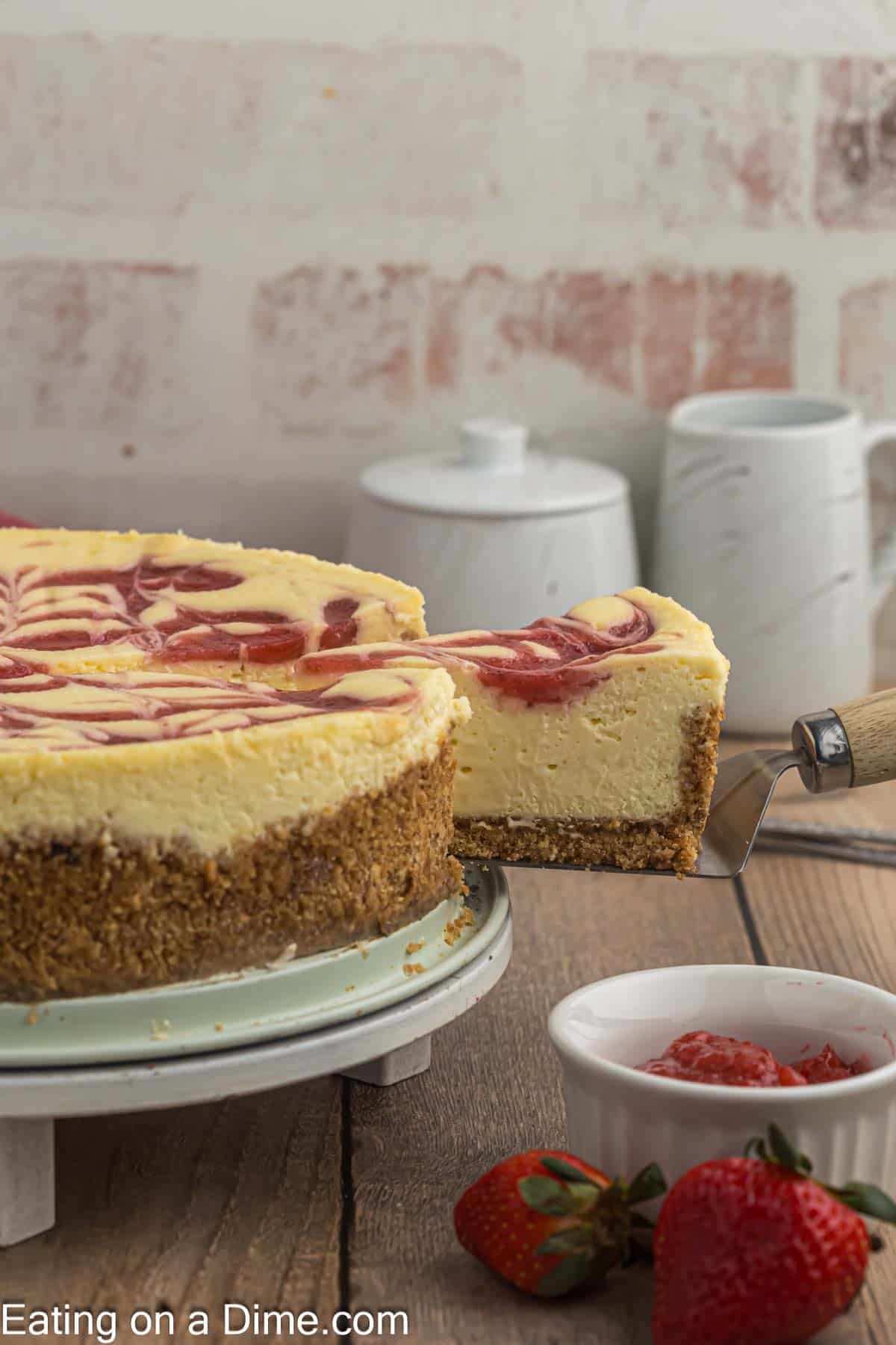 Strawberry Swirl Cheesecake with a slice on a spatula