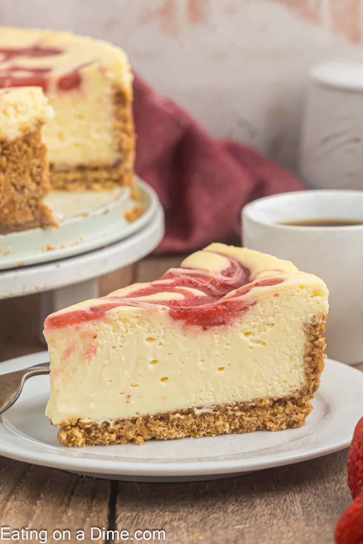 Slice of strawberry swirl cheesecake on a plate