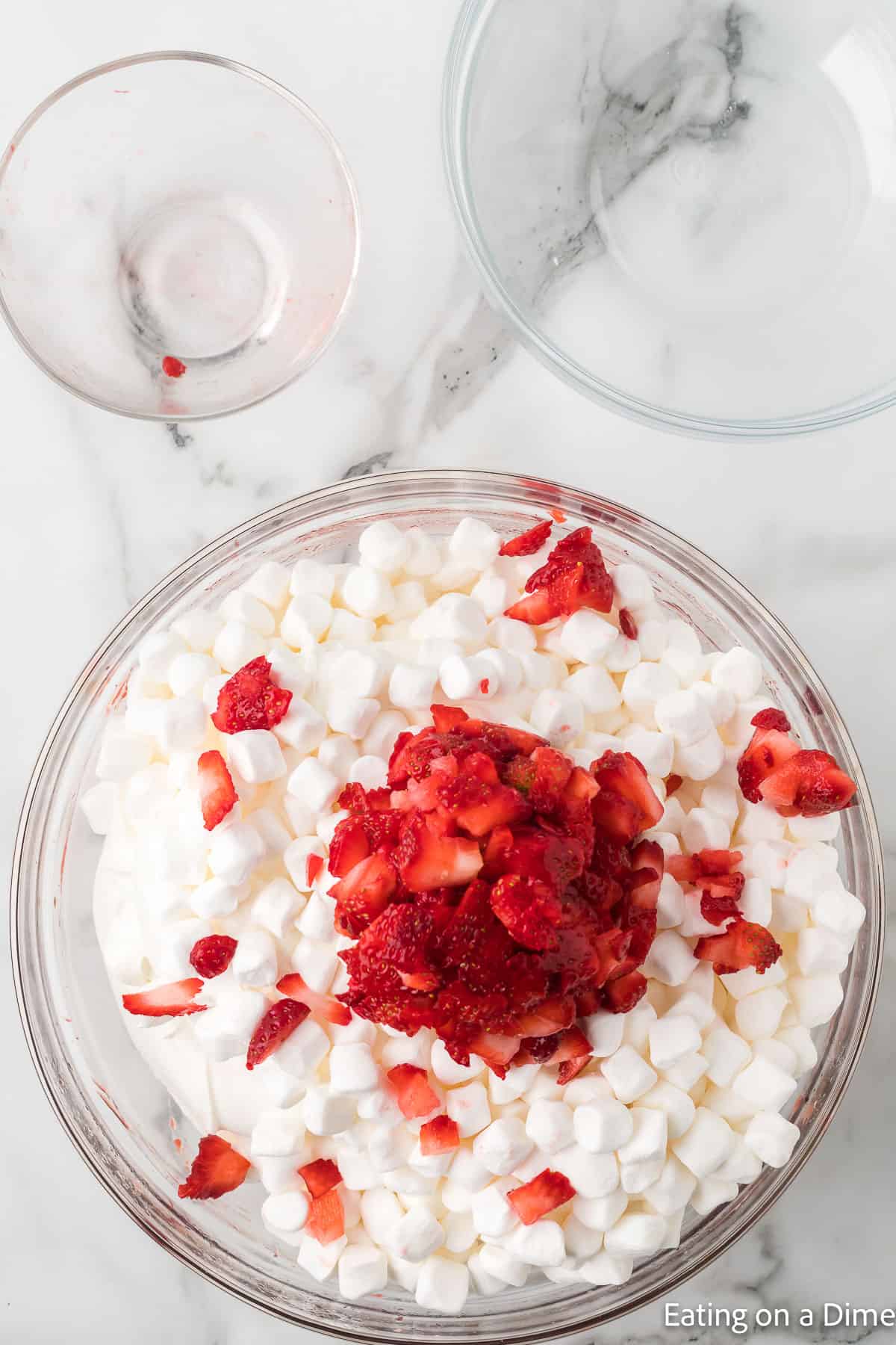 Jello mixture topped with marshmallows and diced strawberries