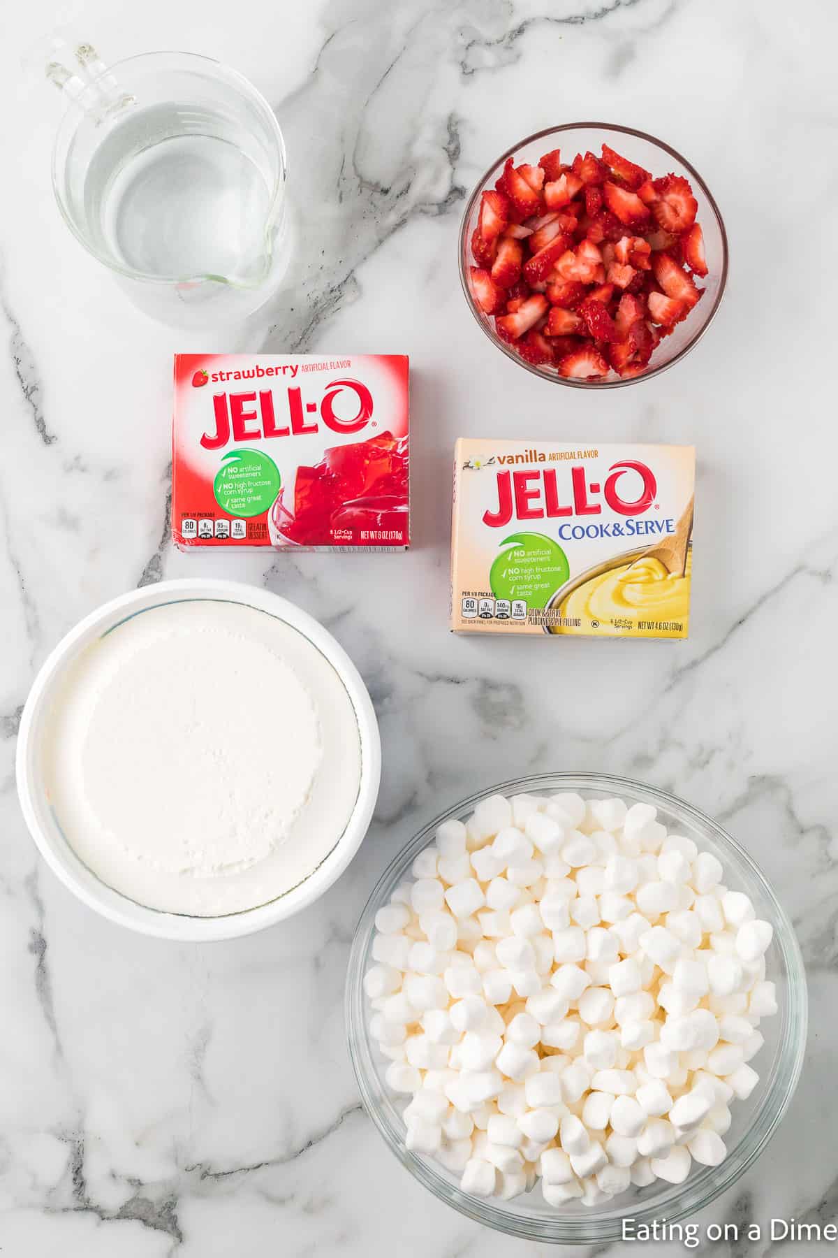 Ingredients - chopped strawberries, marshmallows, cool whip, a box of strawberry jello and vanilla jello and water