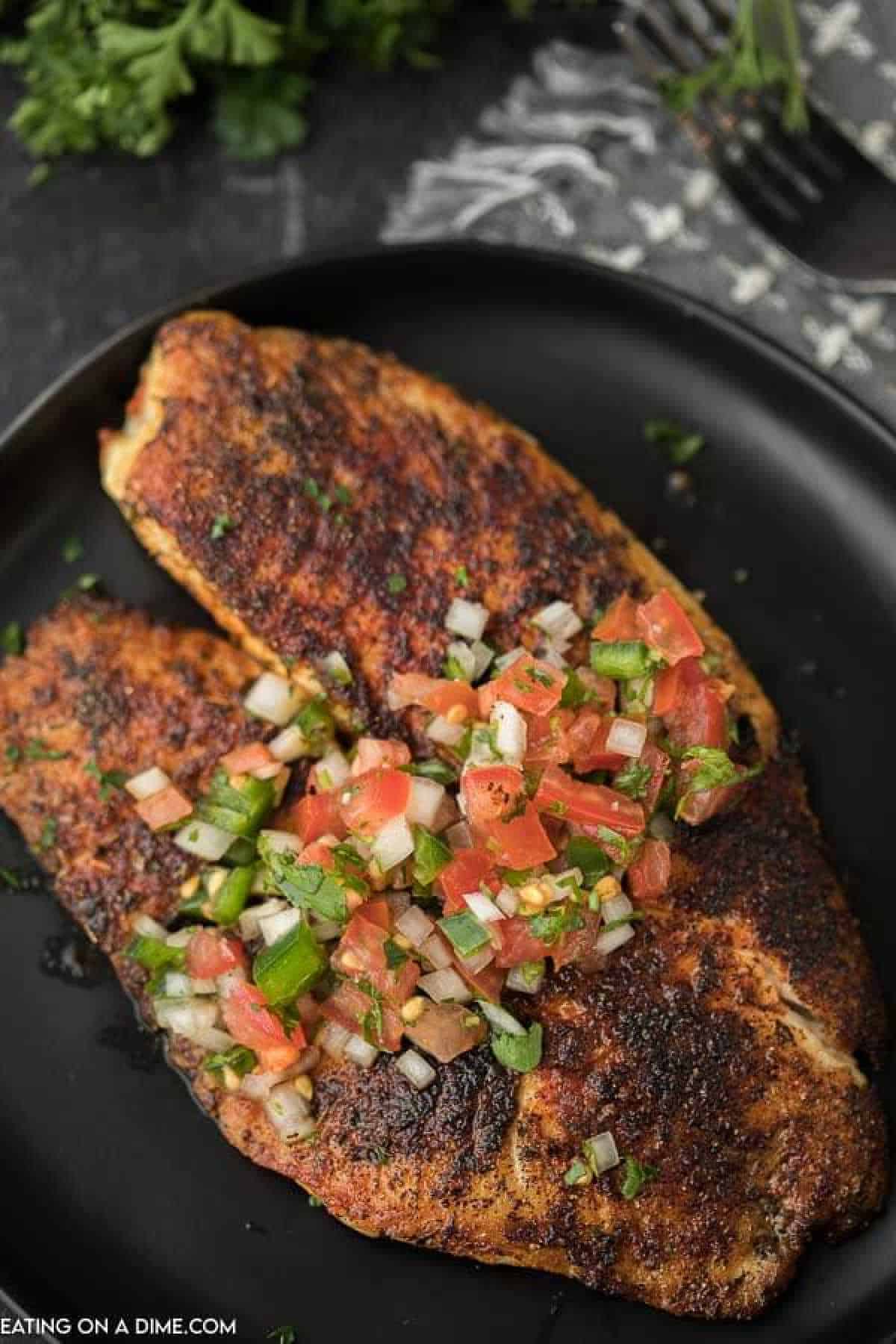 Blackened Tilapia on a plate topped with pico