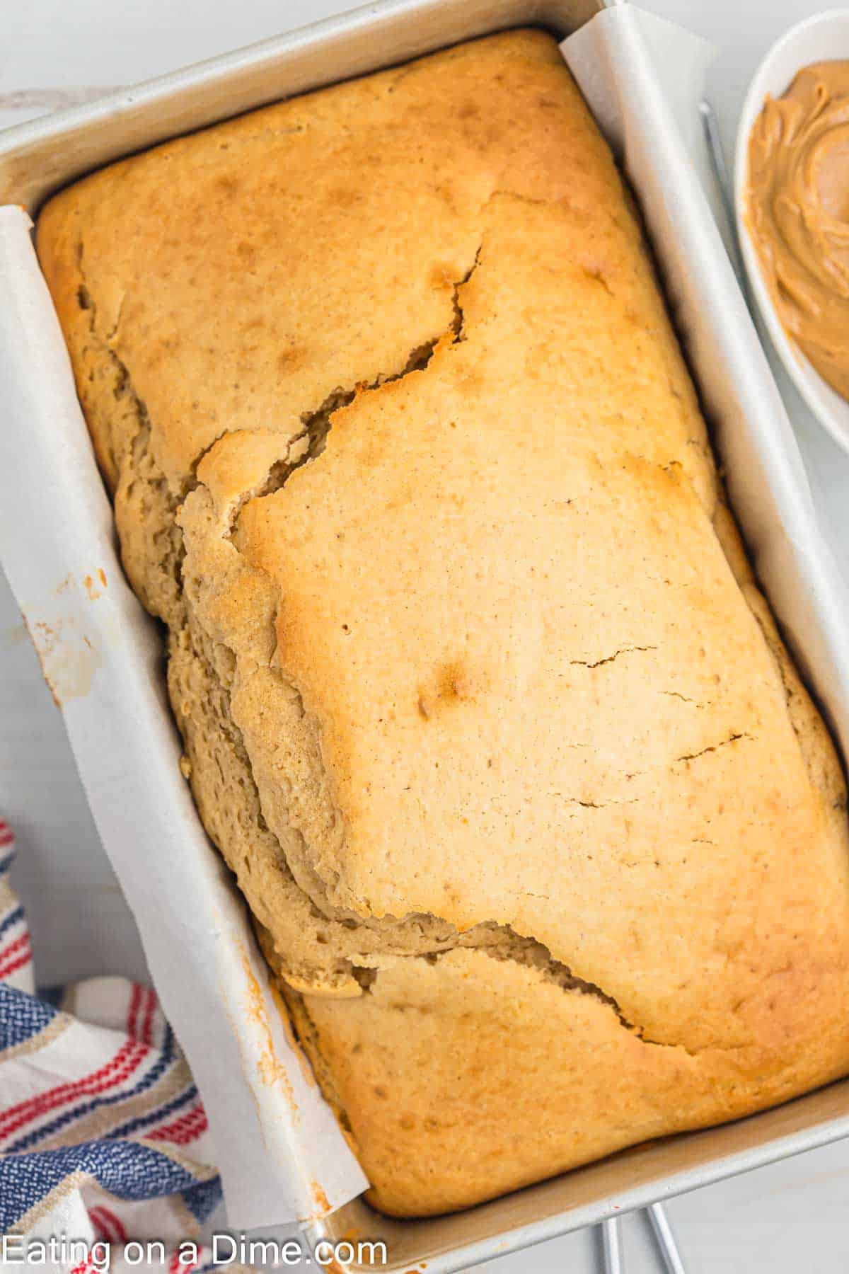 Peanut butter bread baked in a loaf pan lined with parchment paper