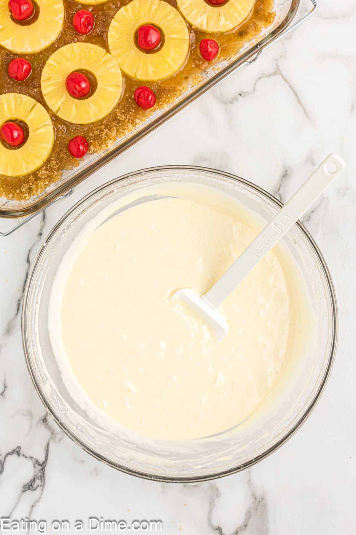 Combining the cake mix ingredients in a glass bowl with a spatula