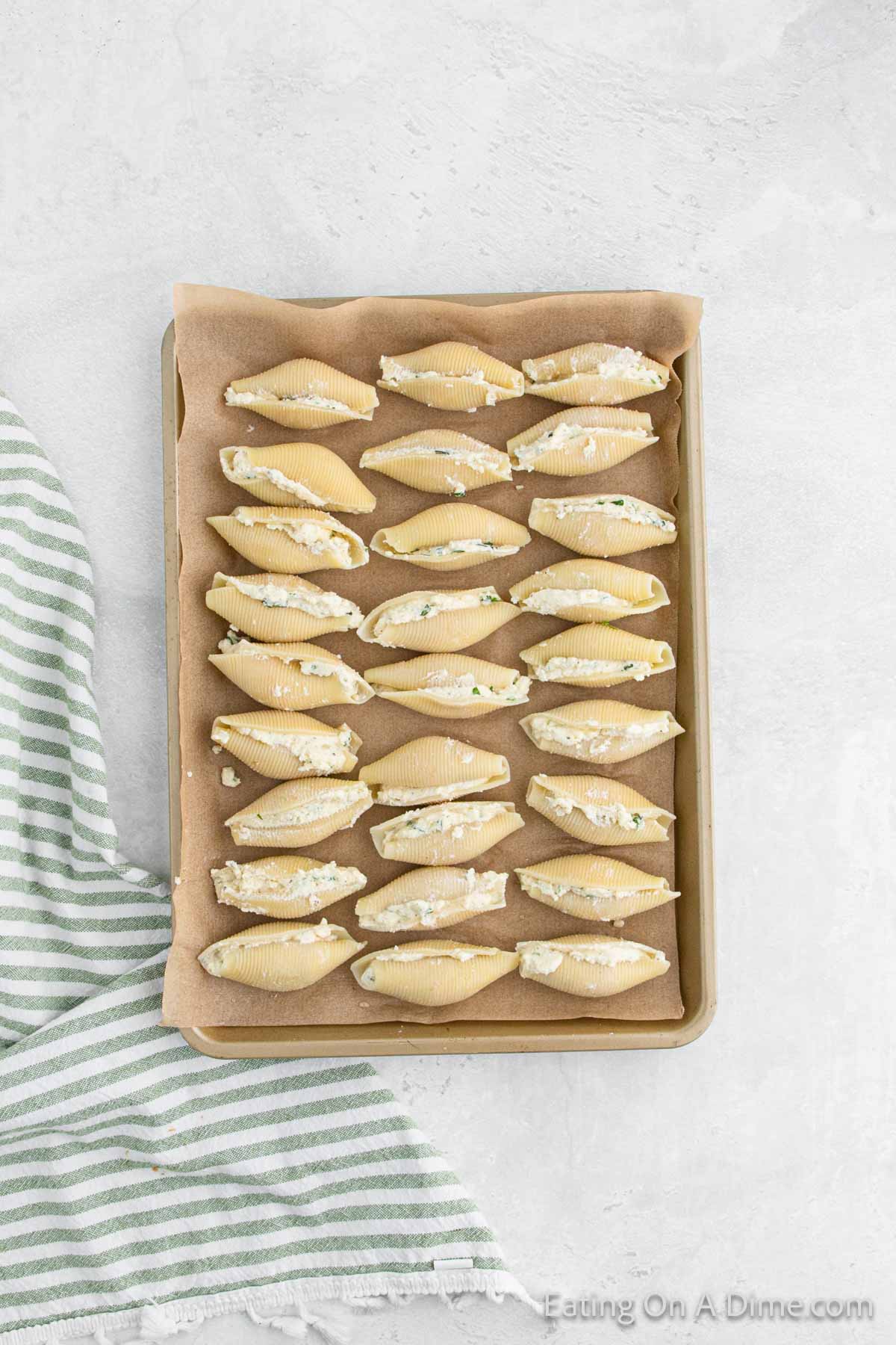 Stuffed shells on a parchment lined baking sheet