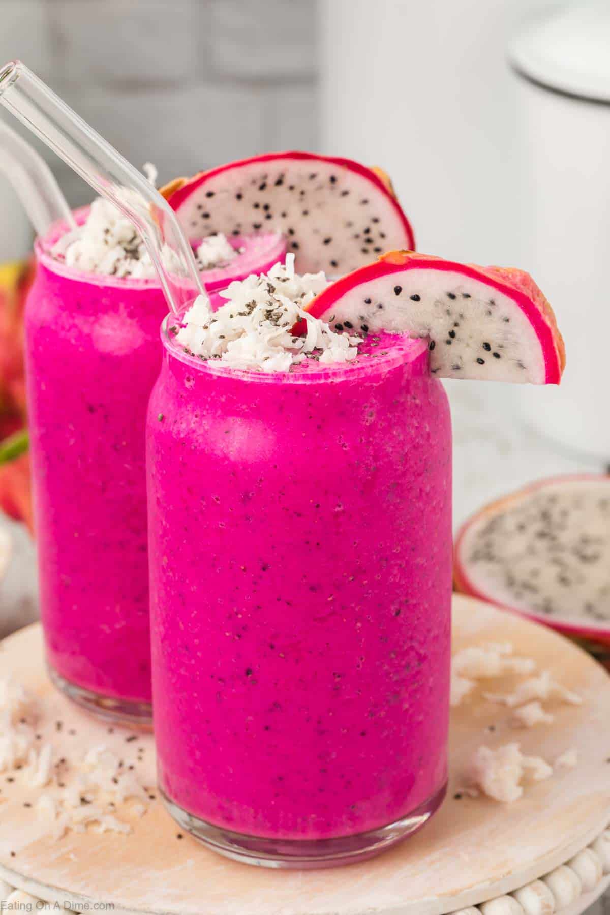 Dragon Fruit Smoothies in a clear glass topped with shredded coconut, slice of dragon fruit