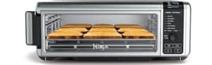 A stainless steel toaster oven with the brand name "Ninja" proudly visible offers more than just style—it’s part of the best air fryer deals. It holds nine slices of toasted bread on its rack and boasts a digital display with several control buttons on the right side for convenience.