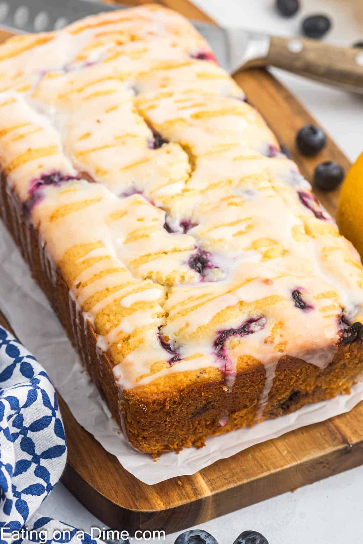 Loaf of lemon blueberry bread on a cutting board