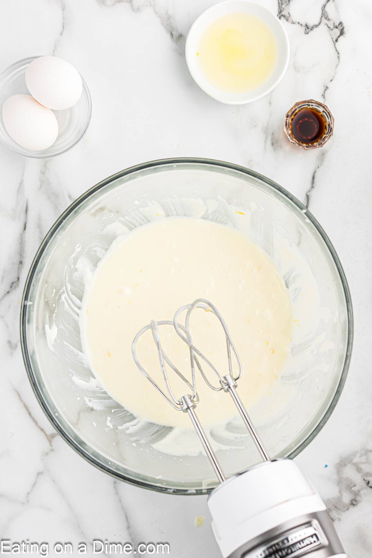 Mixing in the milk and yogurt with the sugar mixture with a small bowl of eggs and vanilla extract