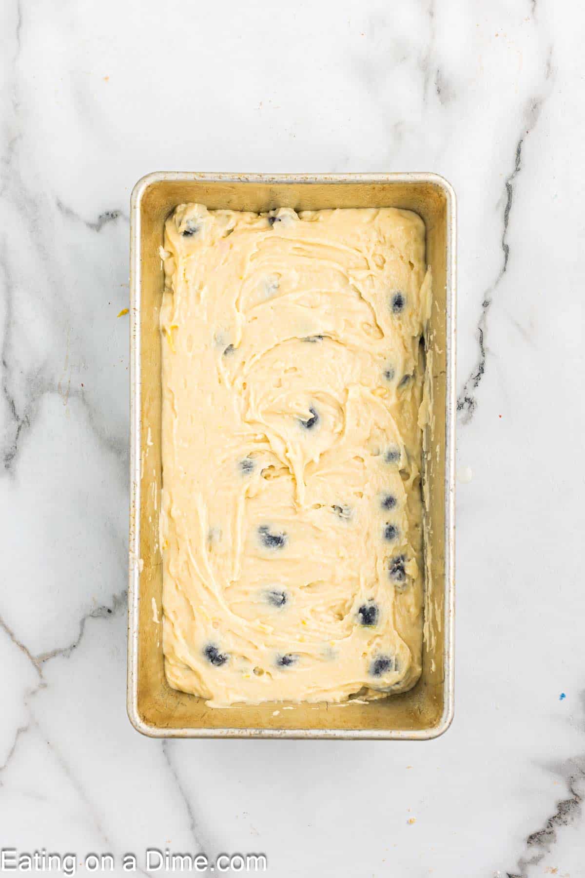 Spreading the lemon blueberry batter in the loaf pan