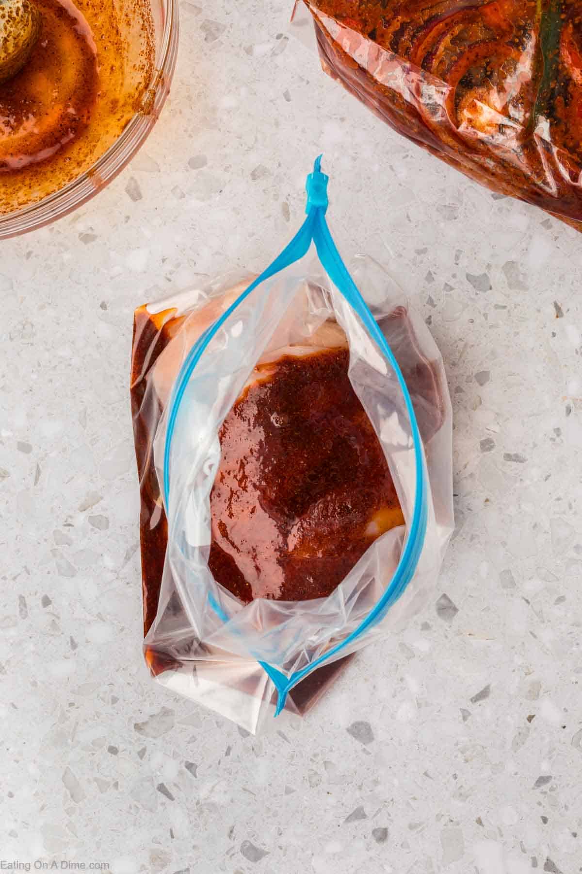 Pouring the marinade over the chicken in a ziplock bag