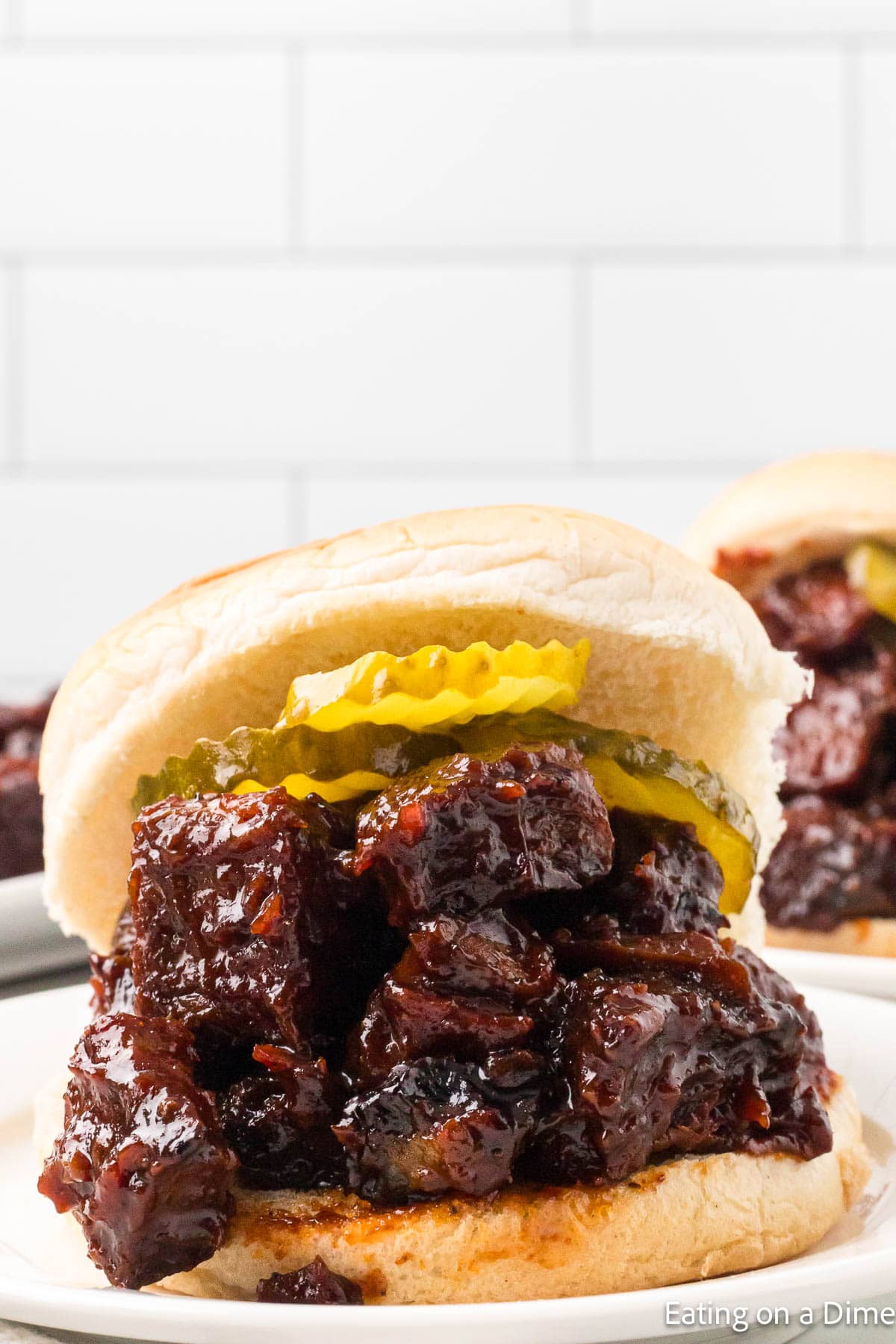 Burnt Ends in a sandwich topped with slice pickles