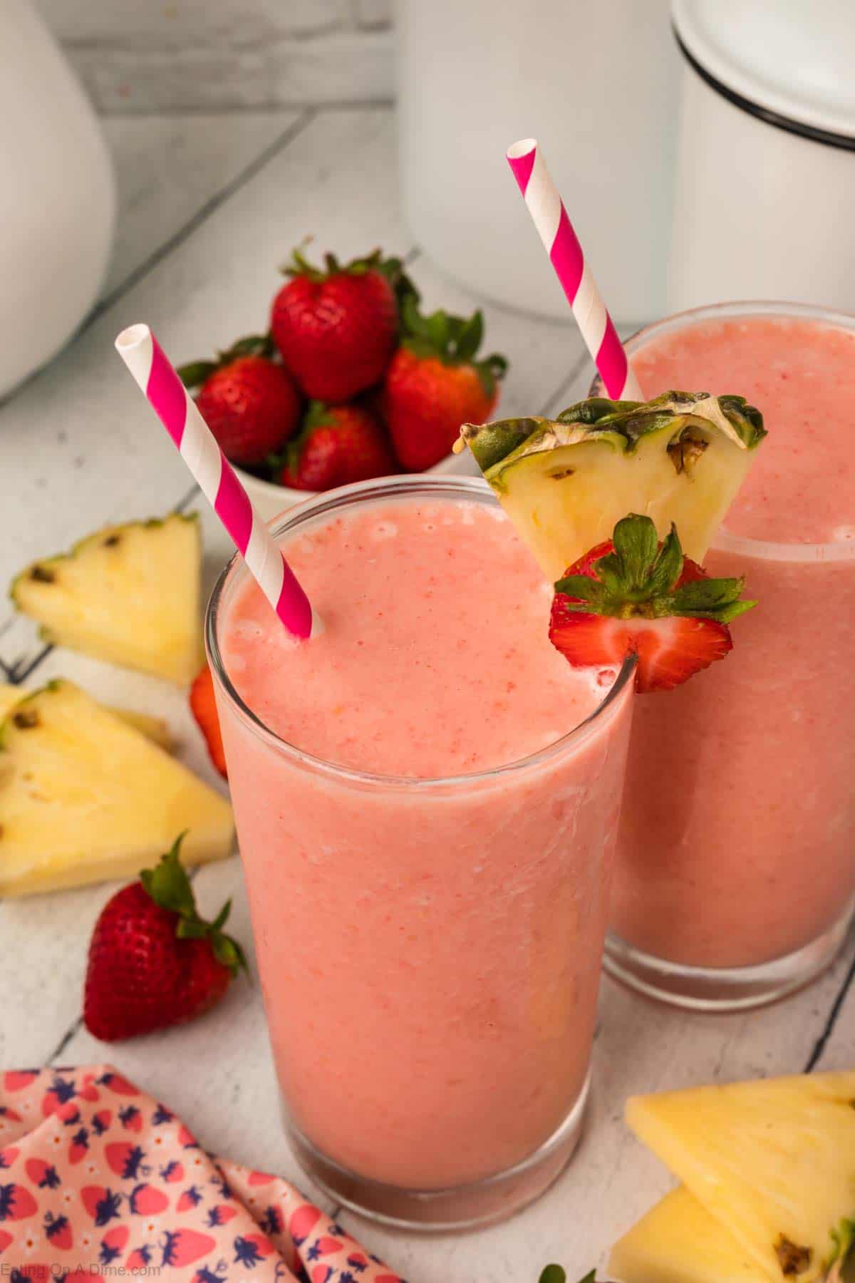 Strawberry pineapple smoothie topped with slice strawberries and pineapple