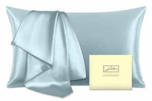 A light blue satin pillowcase is paired with a matching satin sheet, perfect for thoughtful Mother's Day gifts. A cream-colored card with elegant script sits beside them. The fabric appears smooth and glossy, reflecting light for a luxurious look.