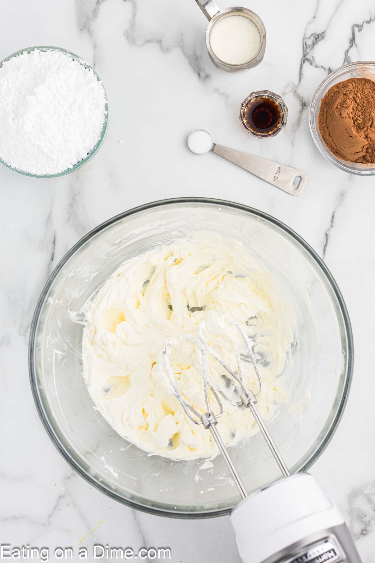 Combining the cream cheese and butter in a bowl with a hand mixer