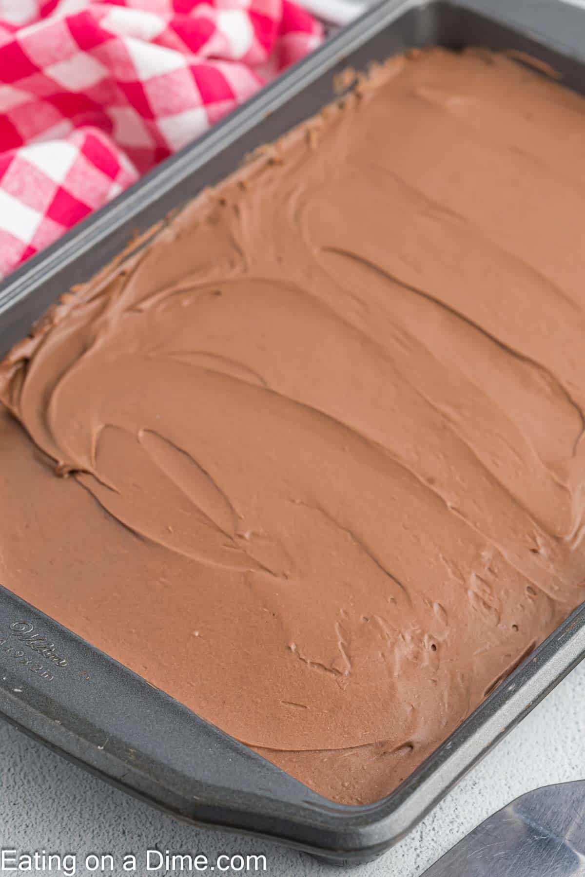 Chocolate cake topped with chocolate frosting in a baking dish