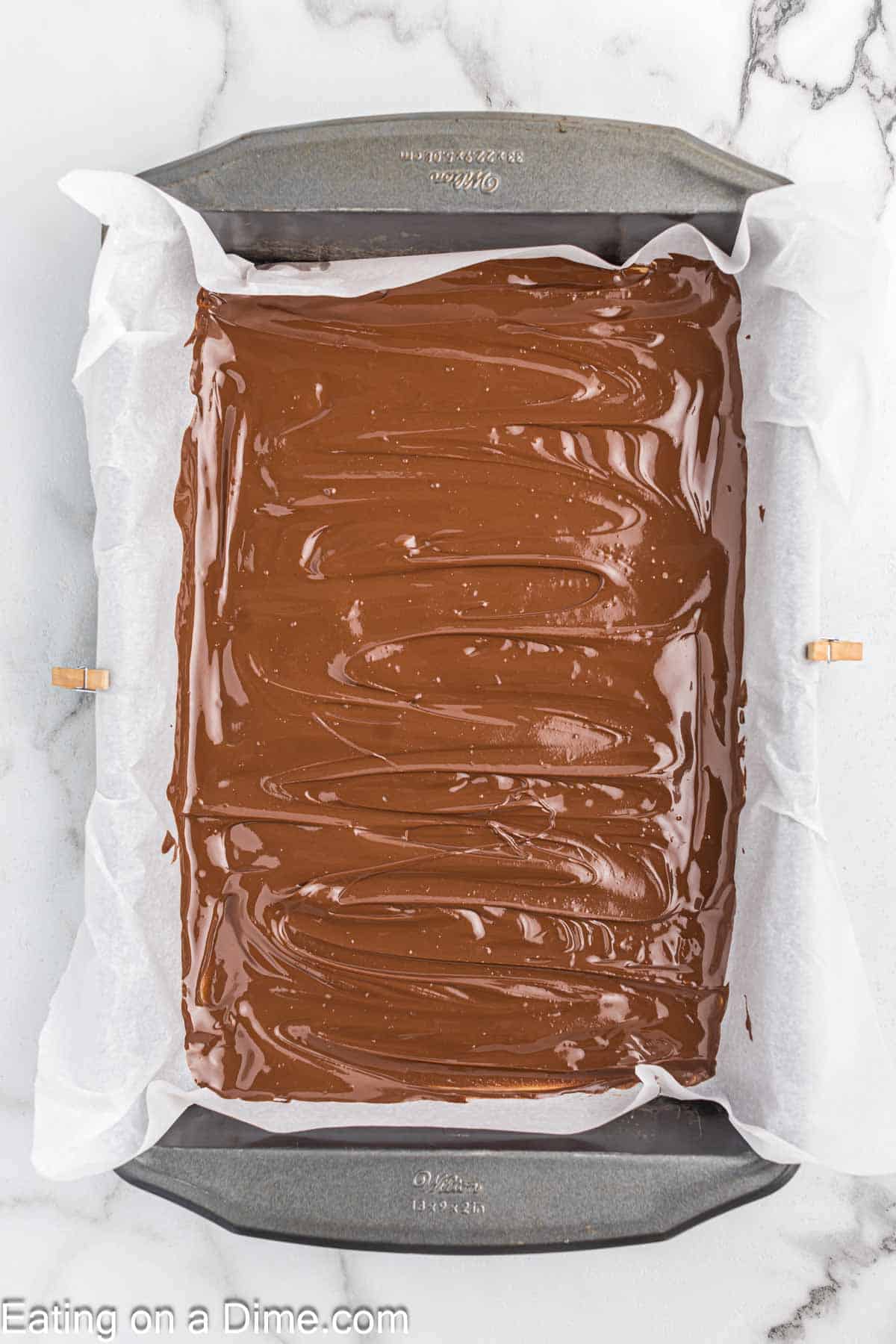 Melted chocolate spread in a parchment lined baking pan