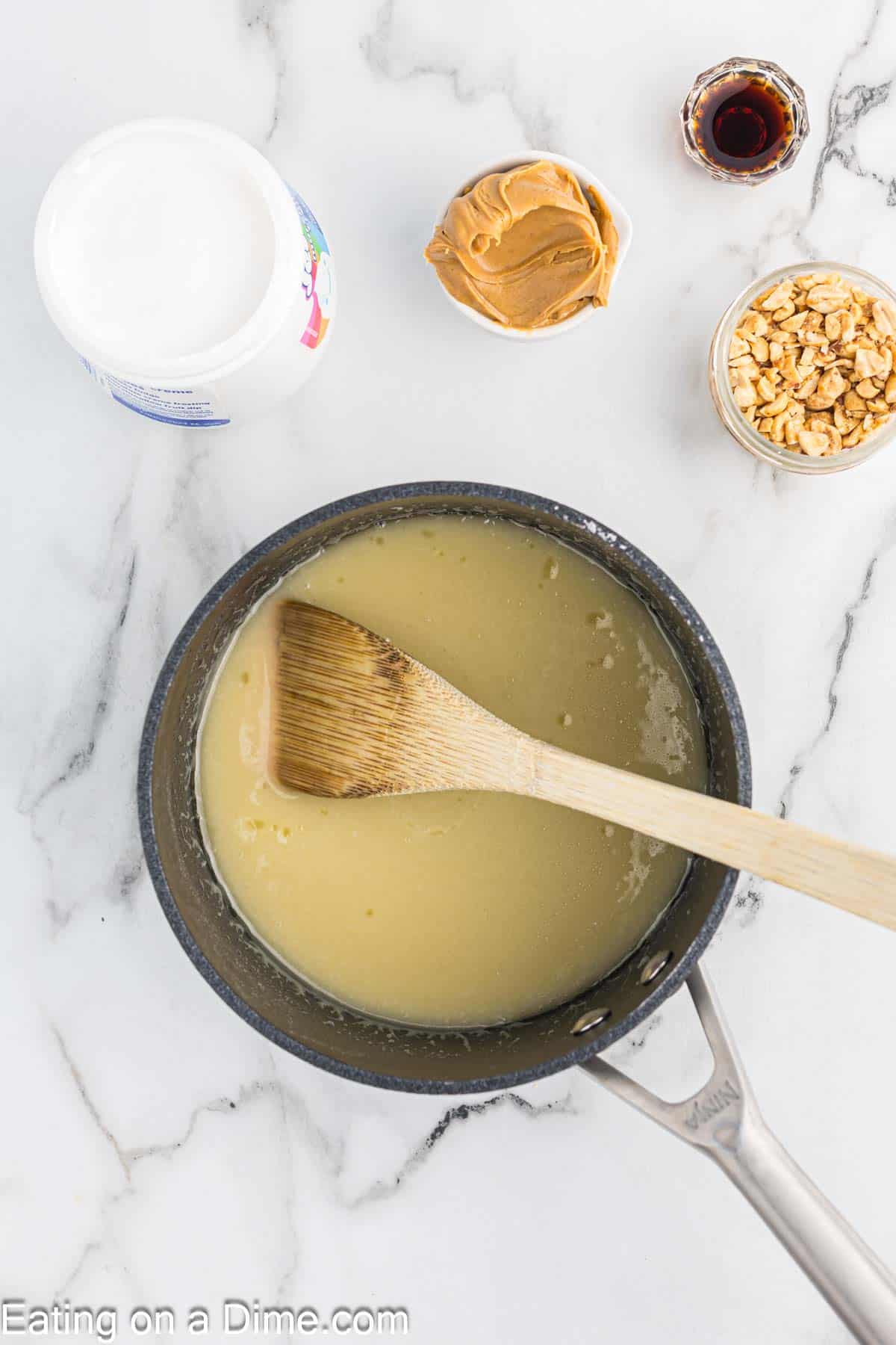 Sugar and evaporated milk heated together in a saucepan with a wooden spoon