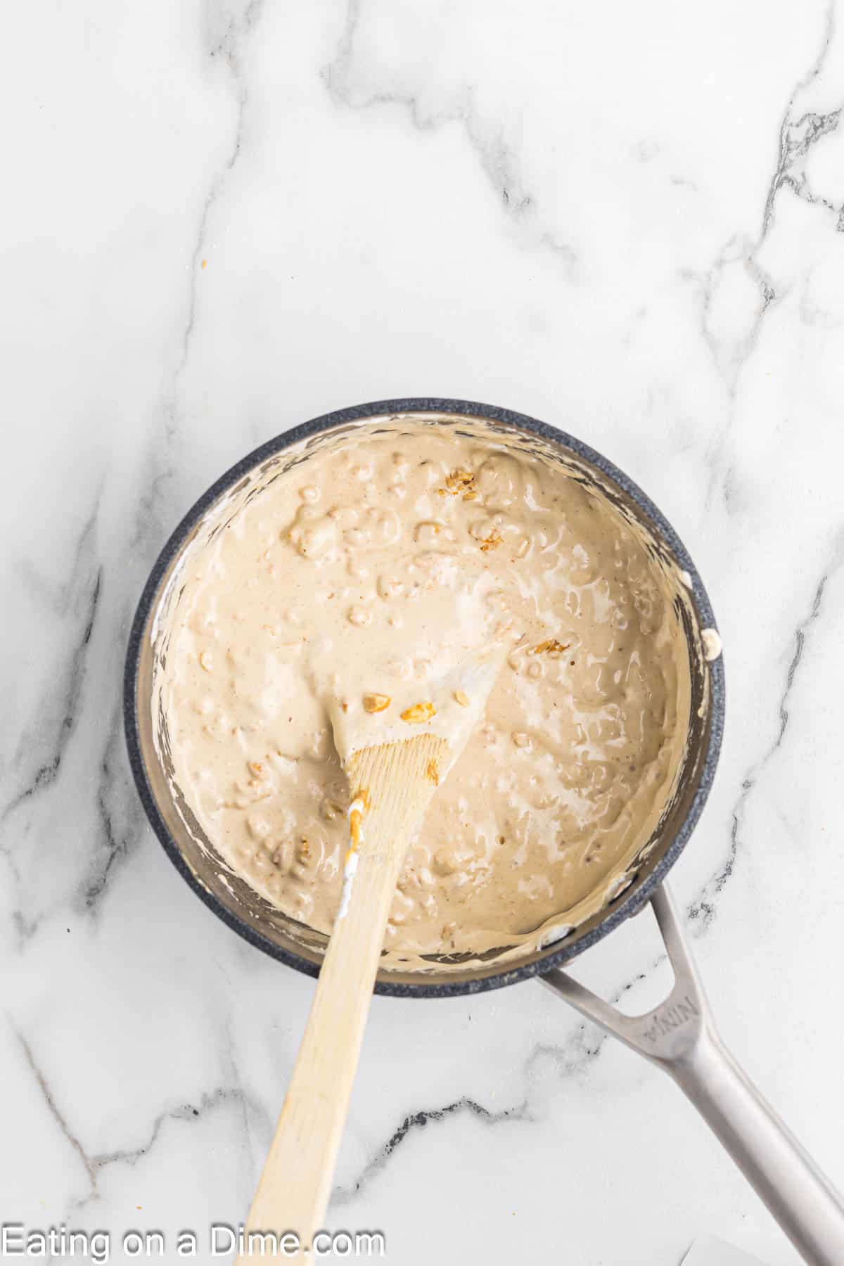 Stirring in the peanuts to the nougat mixture  in the saucepan