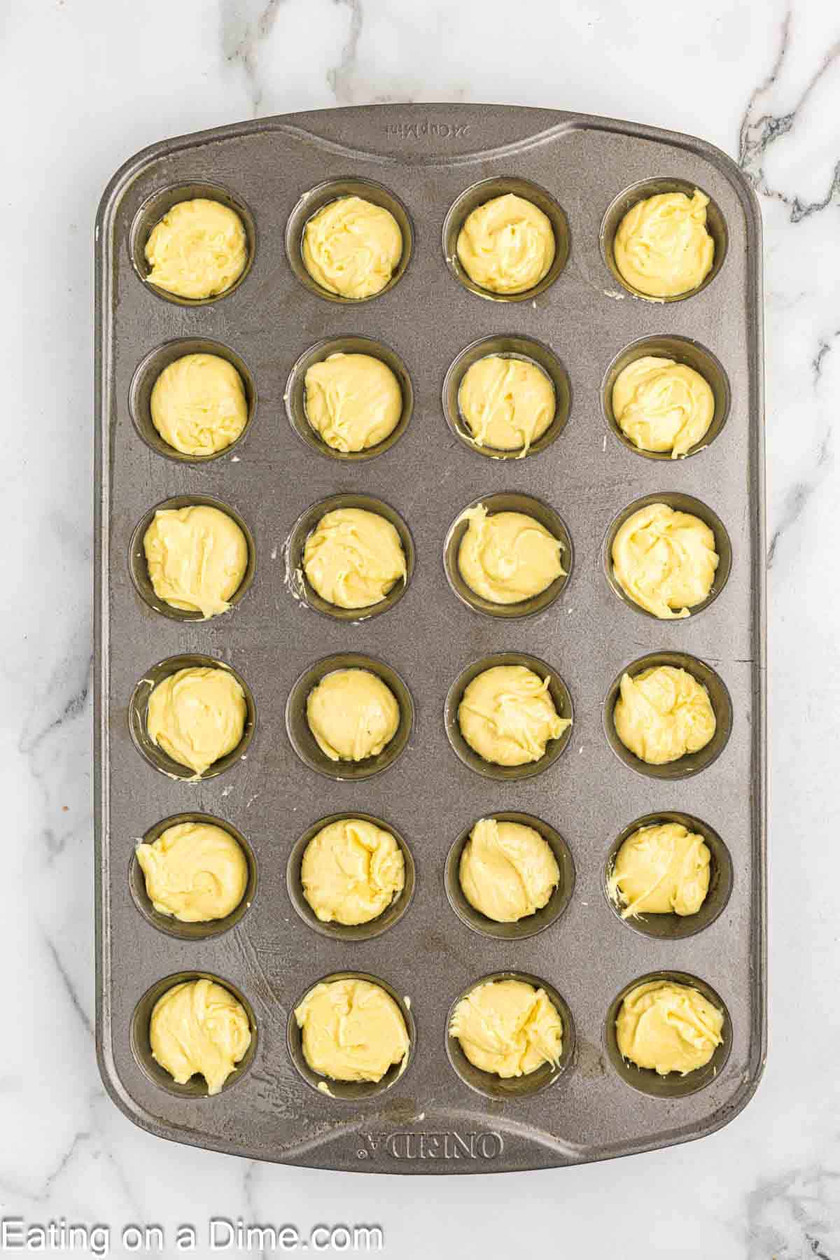 Dividing the lemon blossoms batter in a mini muffin pan