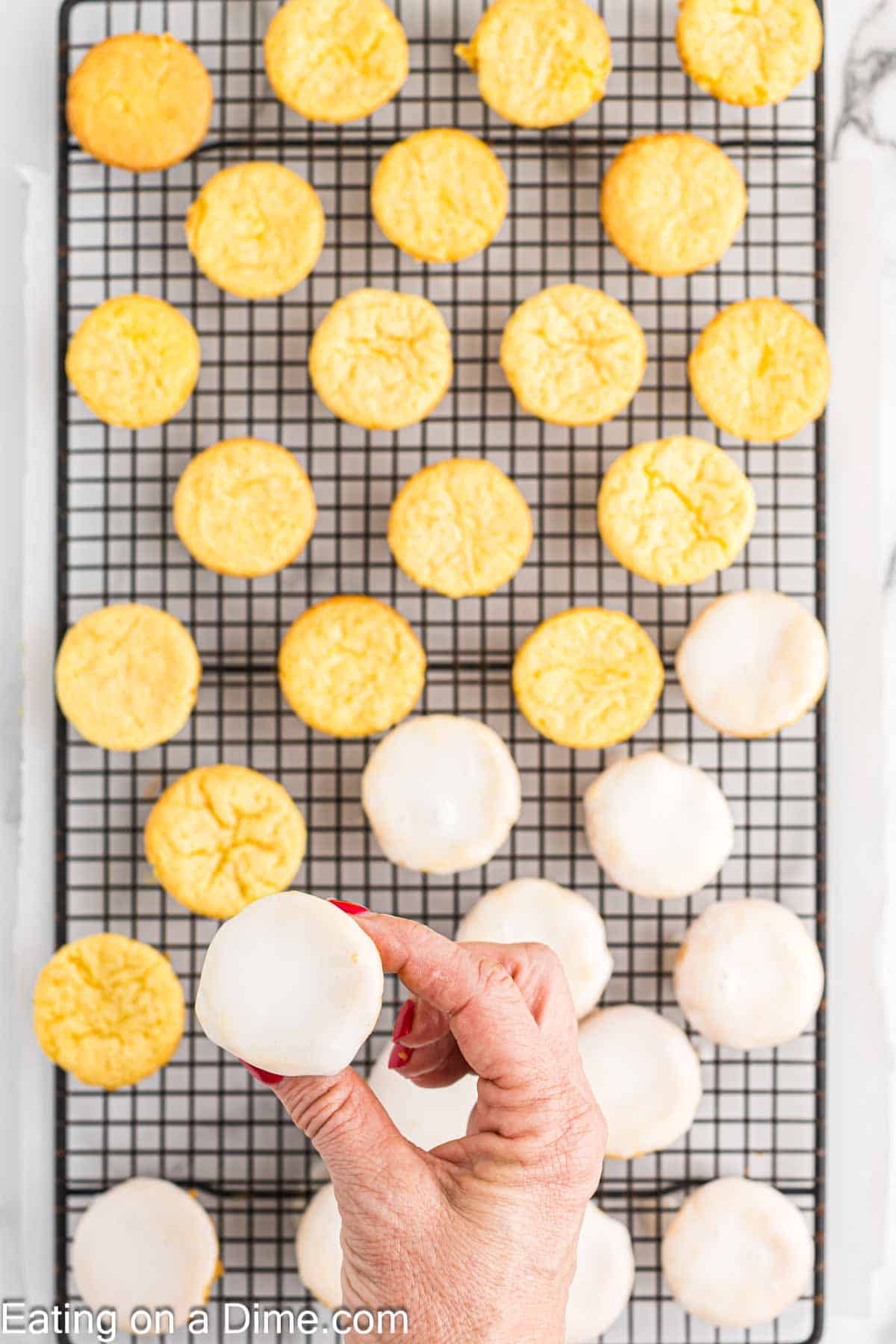 Dipping the lemon blossoms in the lemon glaze and placed on a wire rack