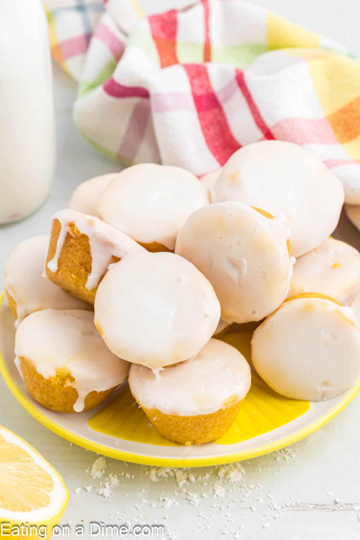 Lemon Blossoms topped with glaze and stacked on a yellow platter