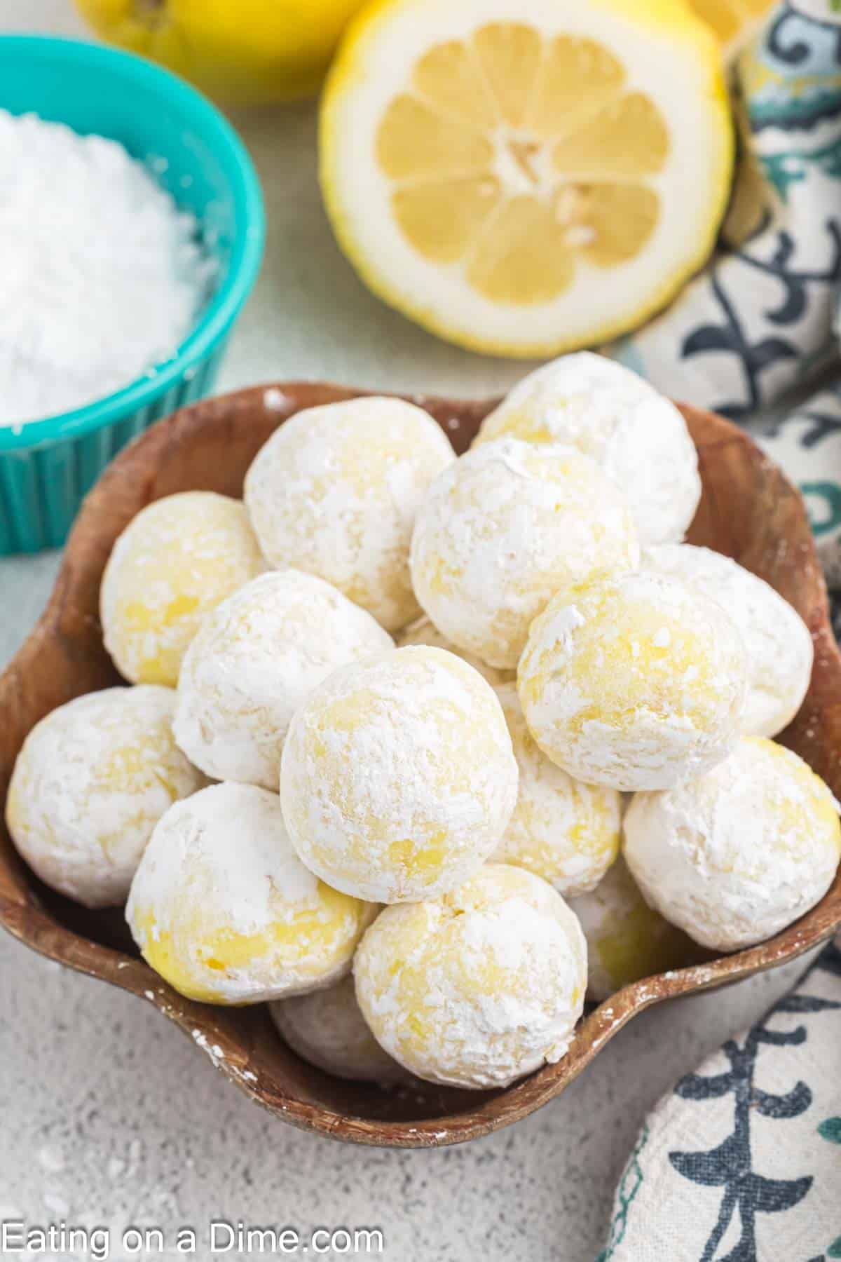 Lemon Truffles coated with powdered sugar stacked in a bowl