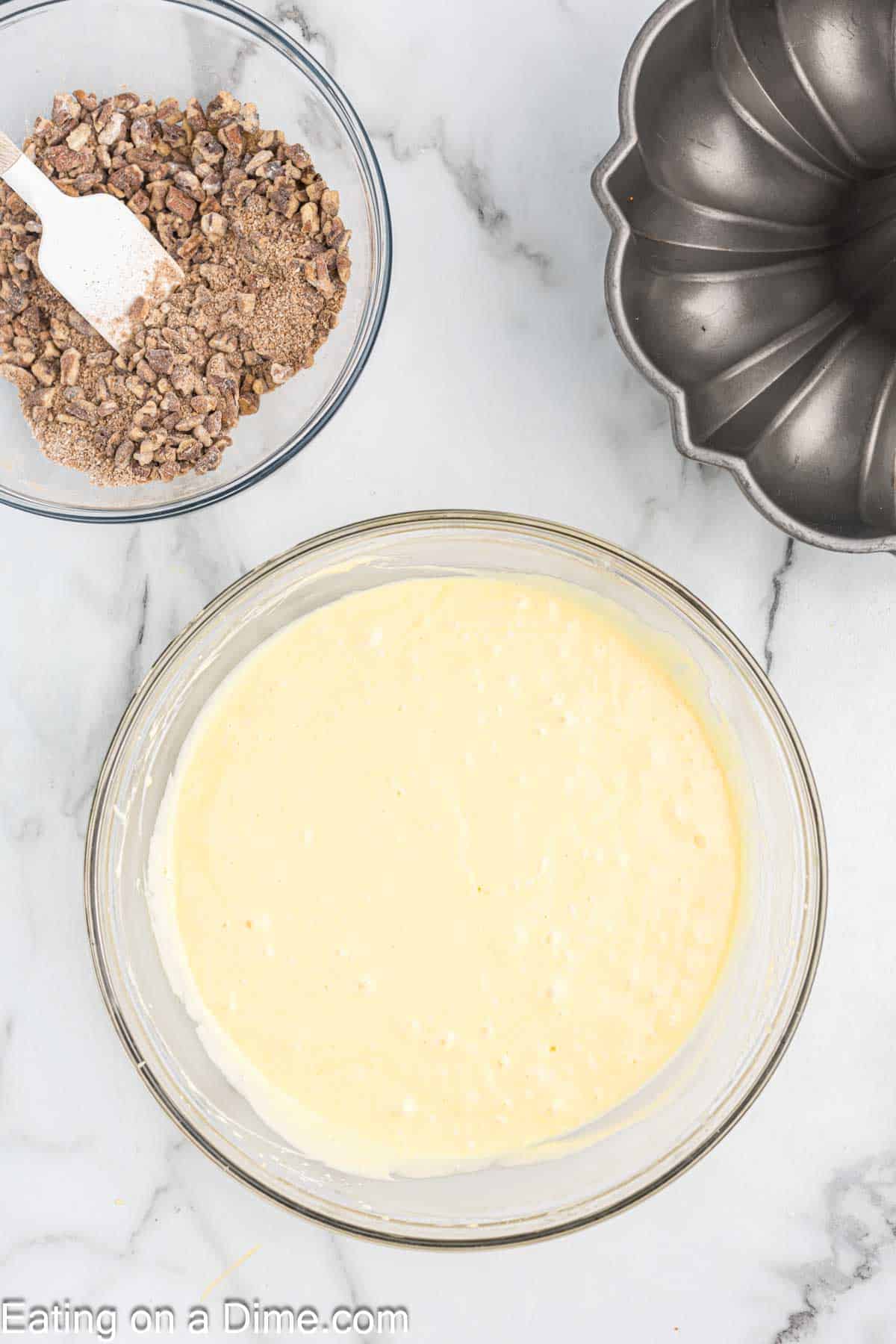 Filling ingredients combined in a small bowl with a bundt pan and cake batter mixture in a bowl on the side