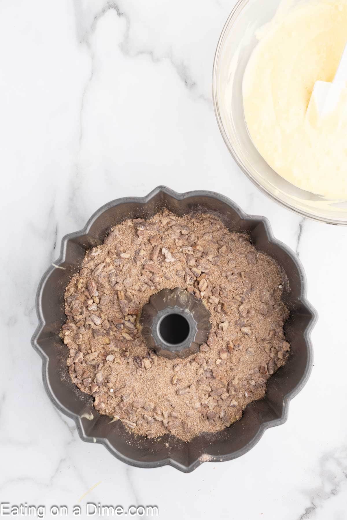 Pecan mixture sprinkled on top of the cake batter in bundt pan