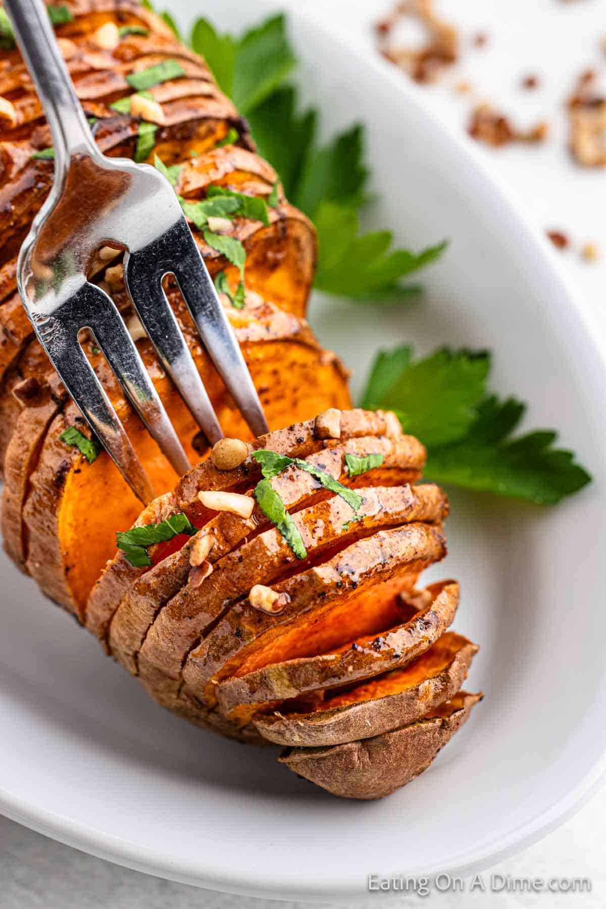Hasselback Sweet Potatoes on a plate with a fork
