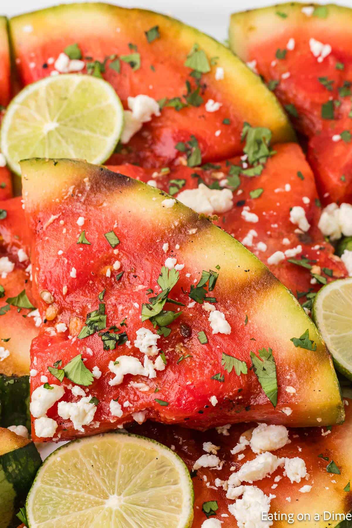 Grilled watermelon topped with cilantro, feta cheese and fresh lime