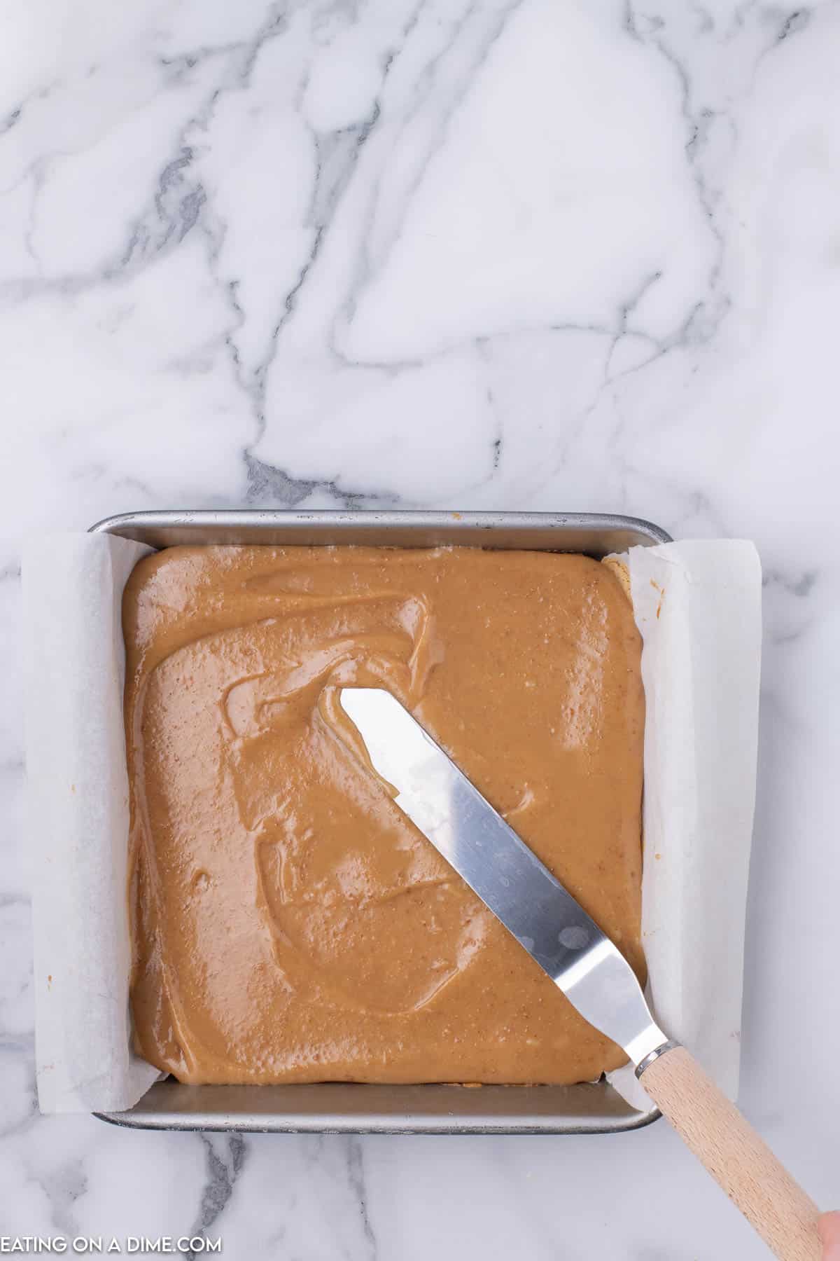 Caramel sauce spread in the baking dish with a knife