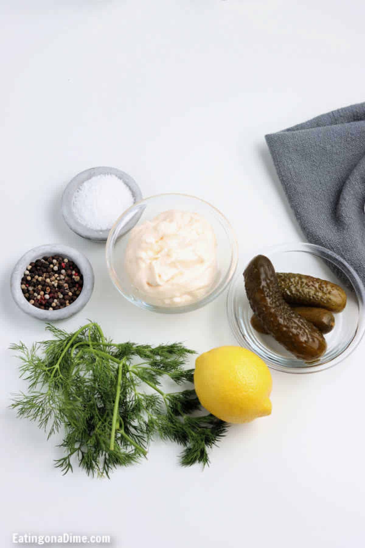 Overview of the ingredients needed to make tartar sauce. - Salt, pepper, mayonnaise, pickles, lemon, fresh dill