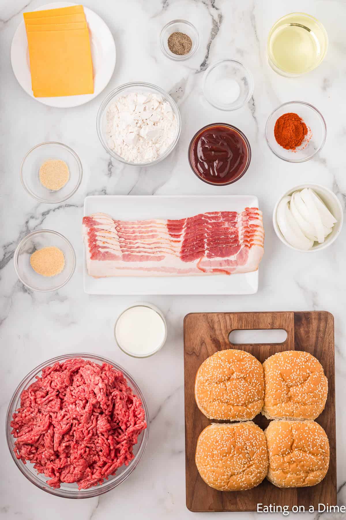 Ingredients - Ground beef, salt, pepper, garlic powder, onion powder, bacon, onion, flour, paprika, buttermilk, vegetable oil, cheese, BBQ Sauce, buns