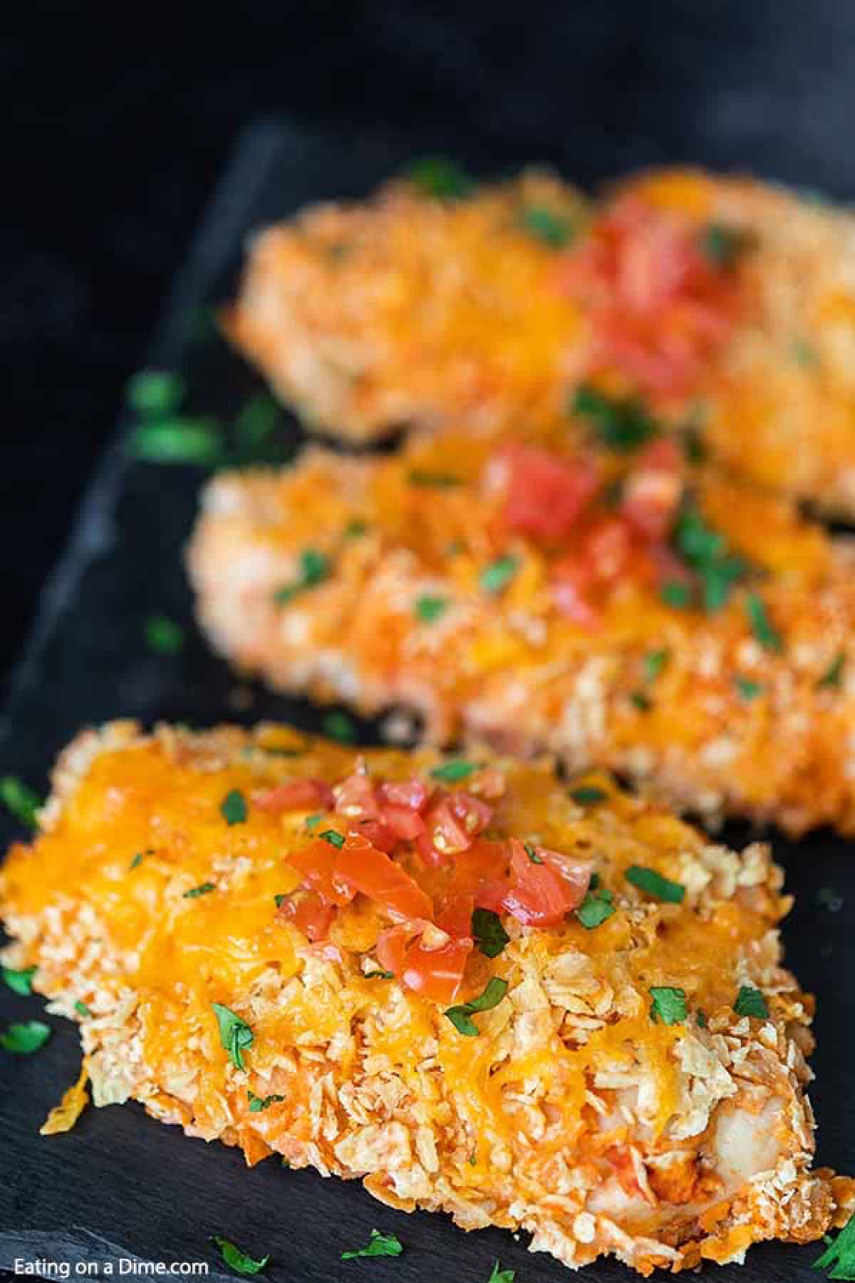 Baked Mexican Chicken topped with melted cheese and diced tomatoes